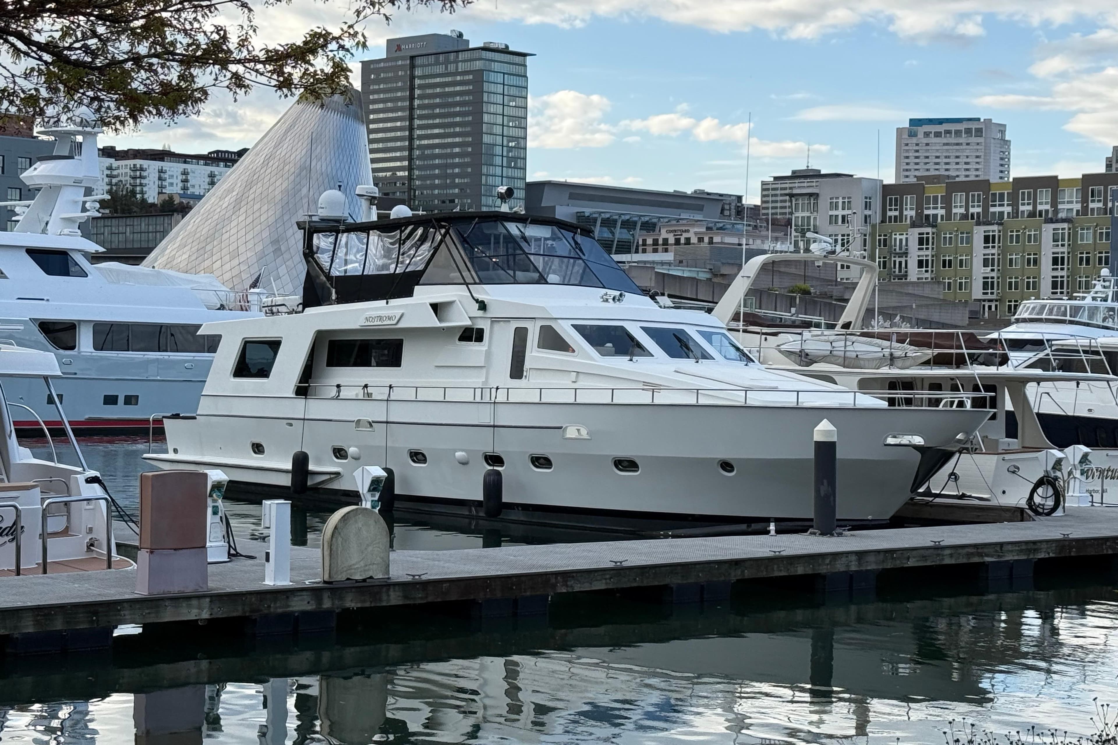 1988 Maiora Motor Yacht docked in urban marina, surrounded by modern buildings.