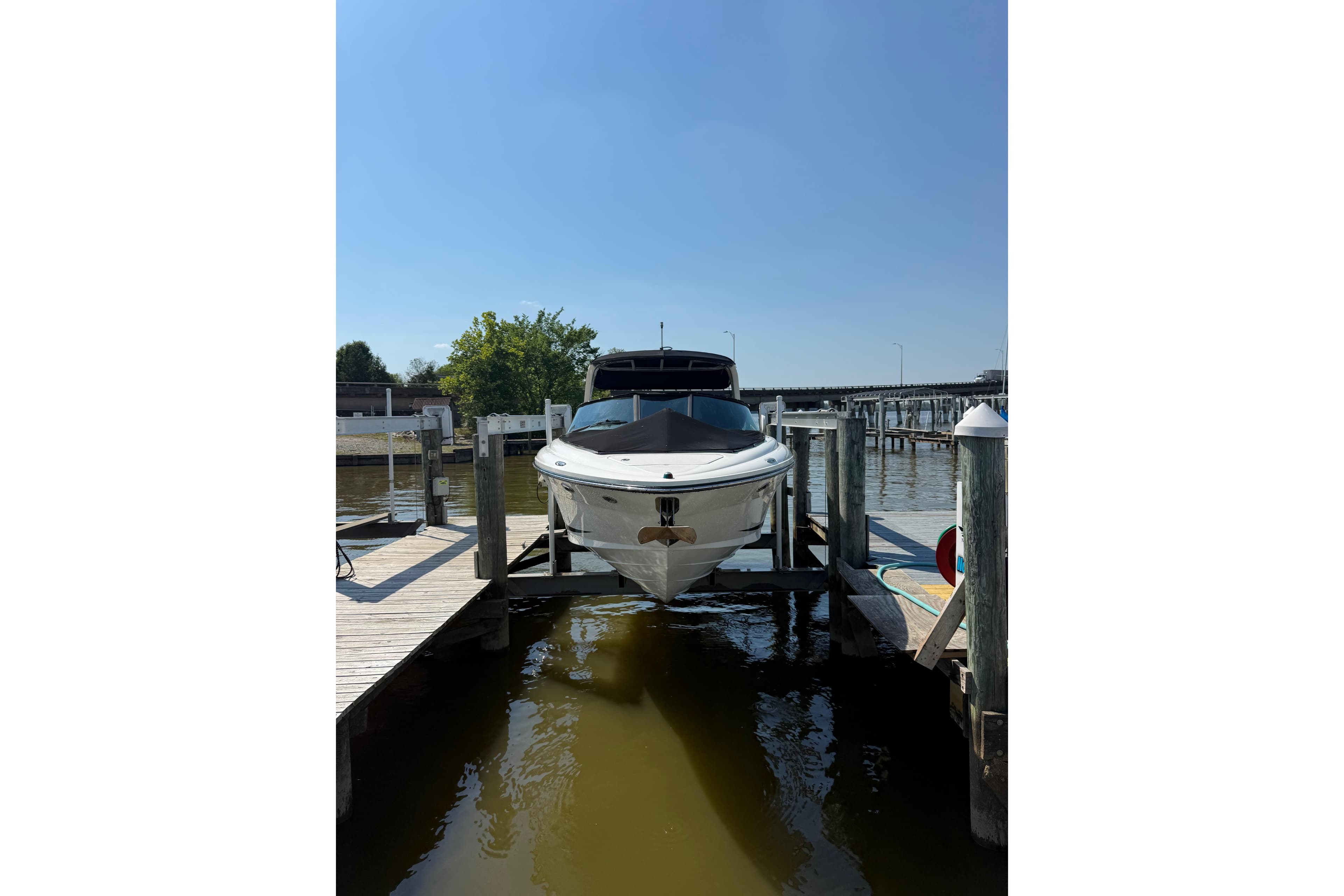 2011 Sea Ray 270 SLX boat docked at a marina under clear blue skies.