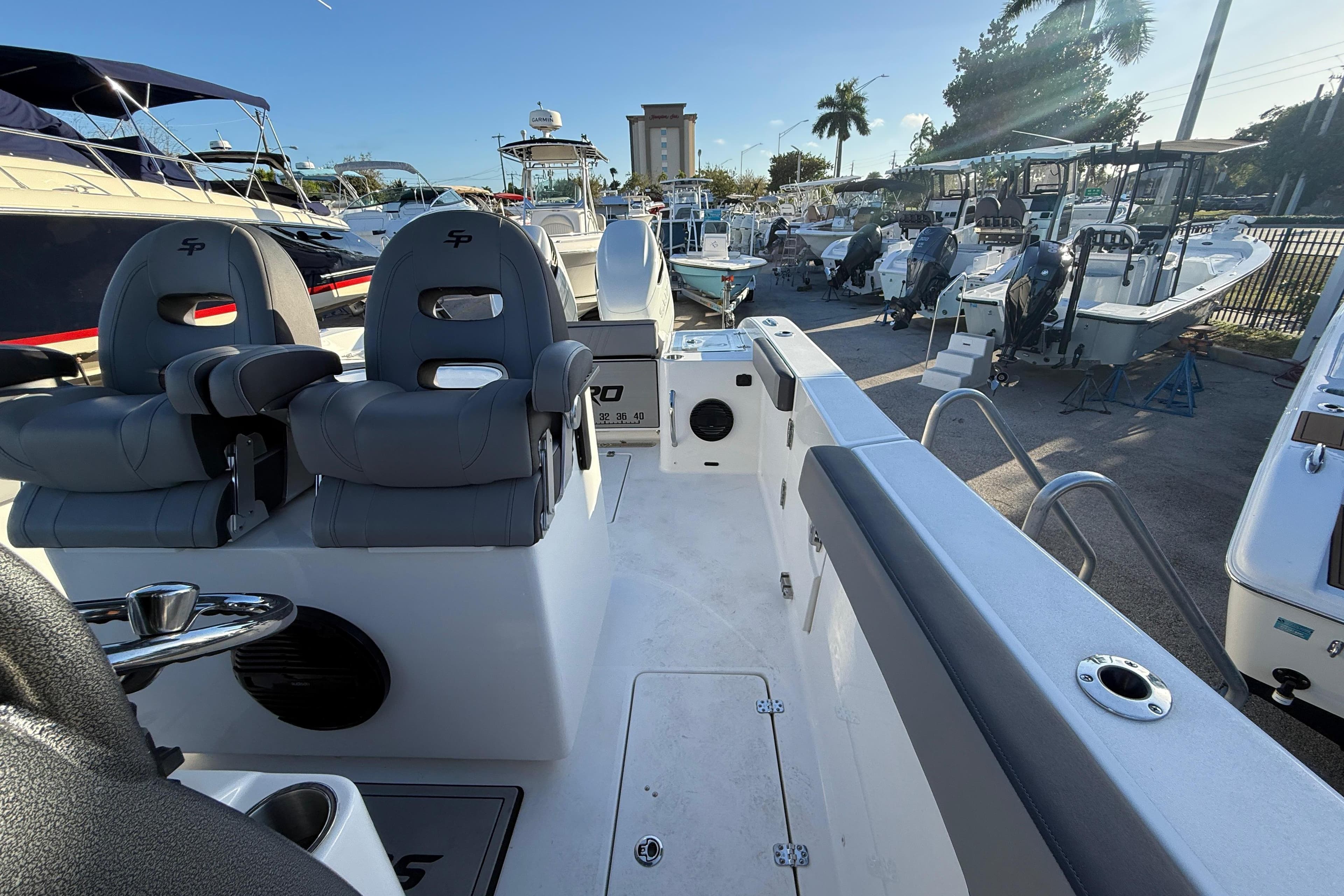 2026 Sea Pro 292 DLX boat interior with dual seats, docked among other boats.