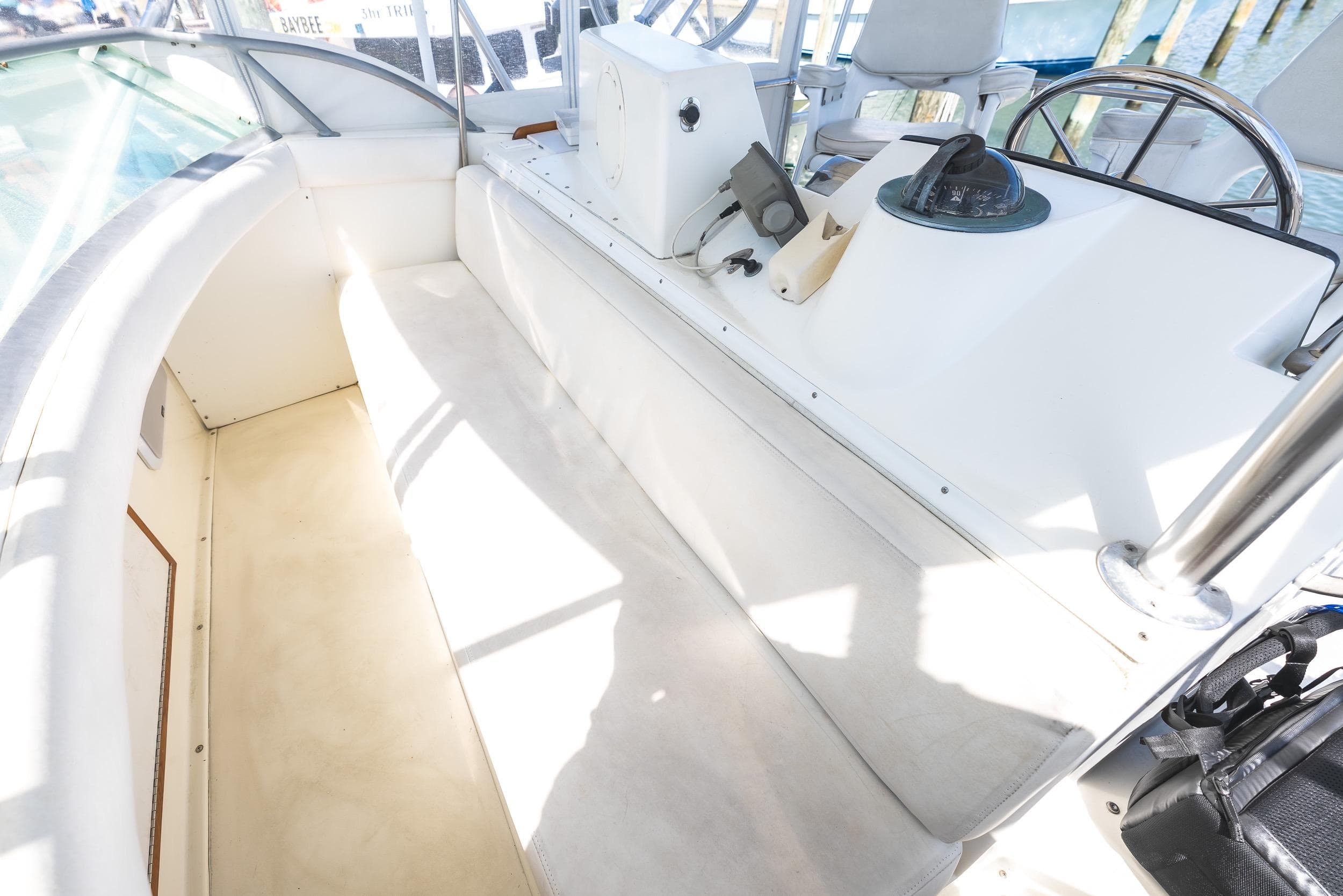 1986 Bertram 35 Flybridge Sportfish helm area with seating and navigation equipment.