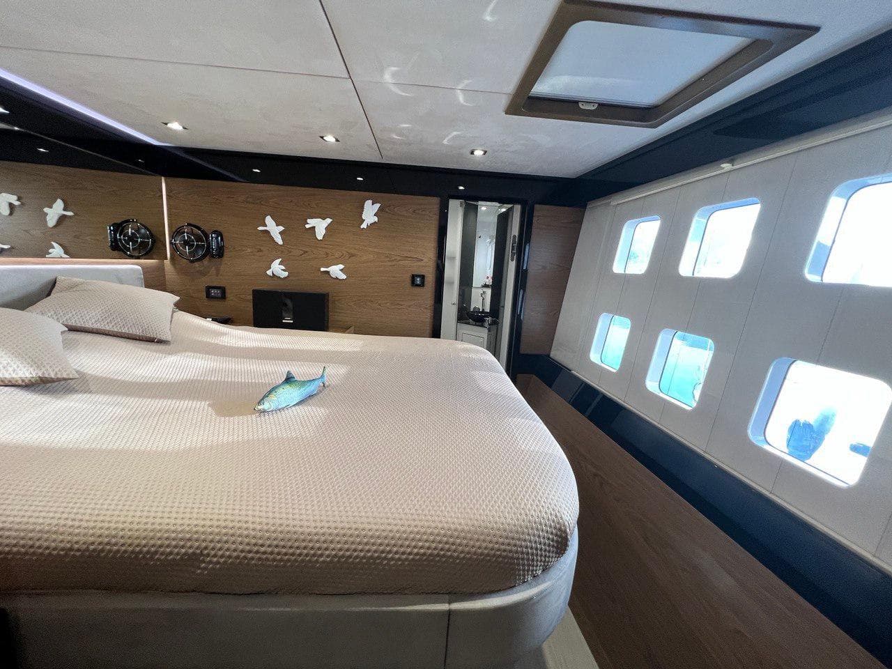 Luxurious Sunreef 60 LOFT 2015 yacht bedroom with modern decor and large windows.