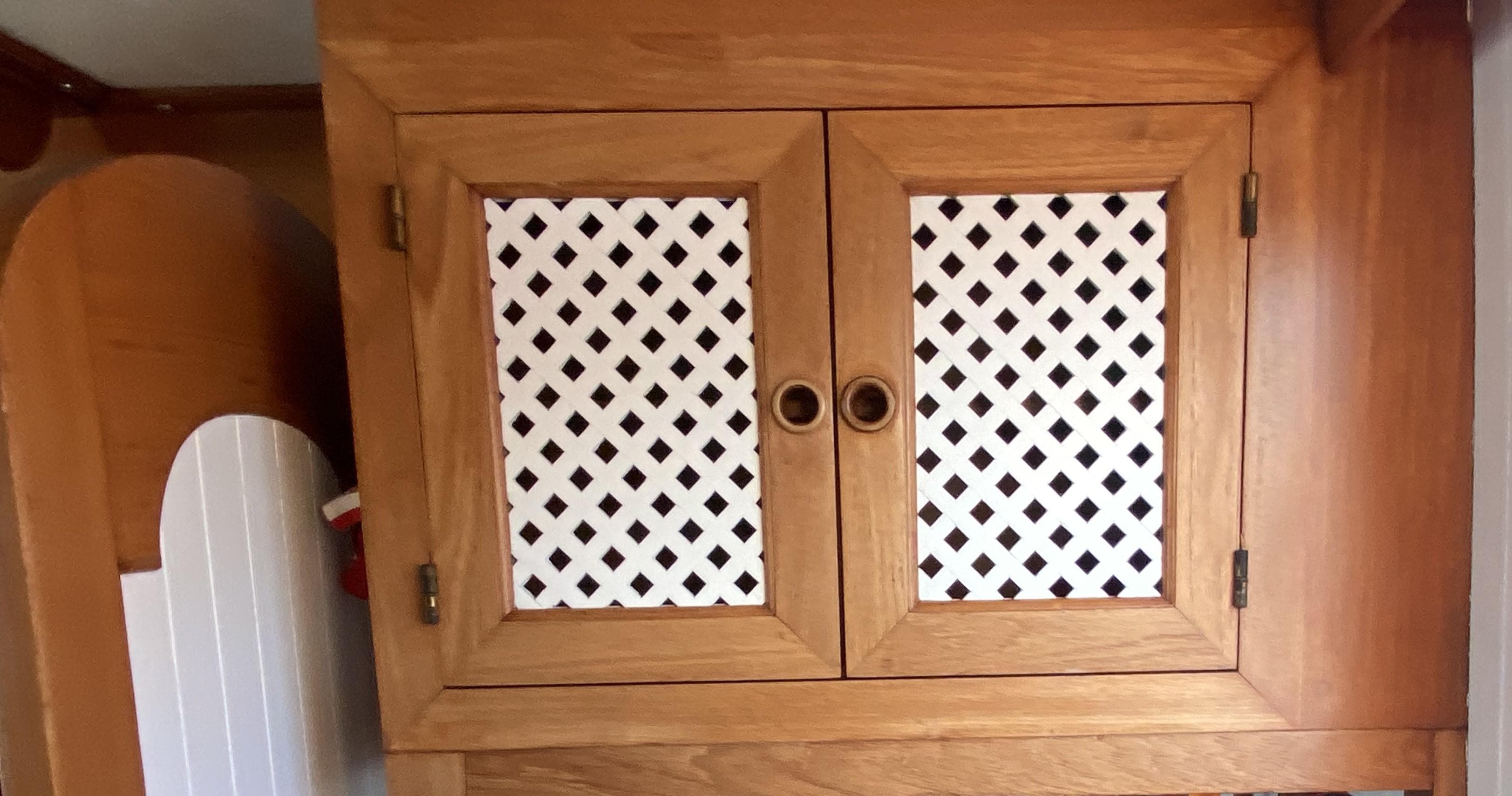 Wooden cabinet with lattice doors on a 1983 DeFever 41 boat.