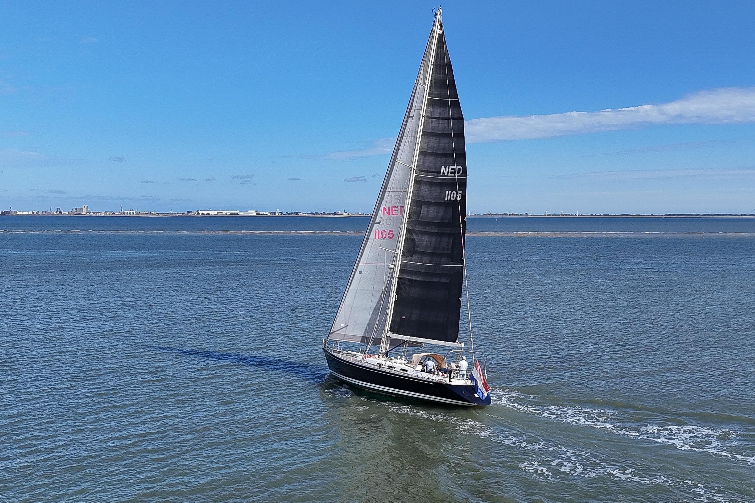 Sailing yacht Standfast 56 from 1991 cruising on open water under clear blue skies.