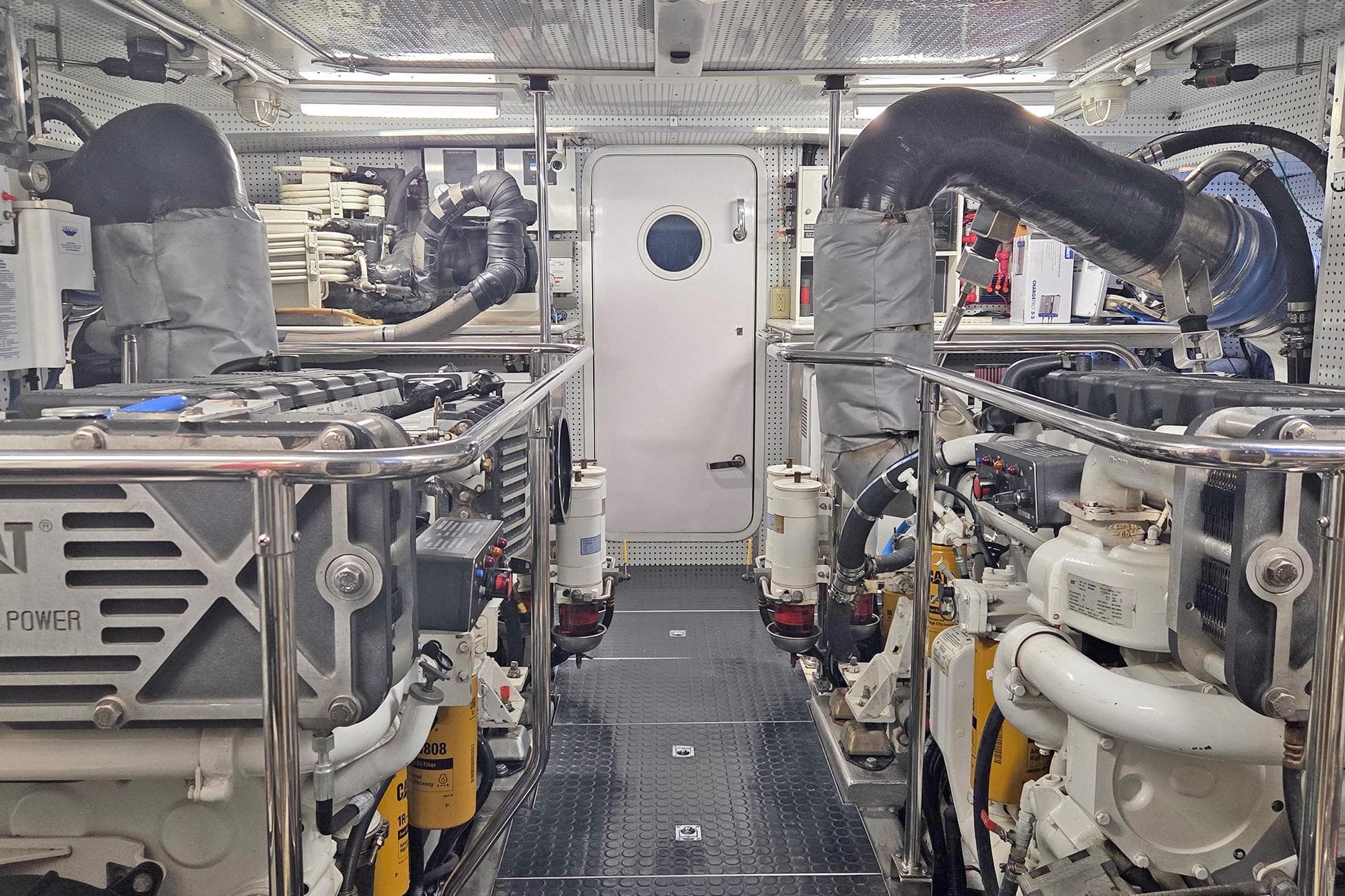 Engine room of 2008 Outer Reef Yachts 650 Motoryacht, showcasing dual engines and mechanical systems.