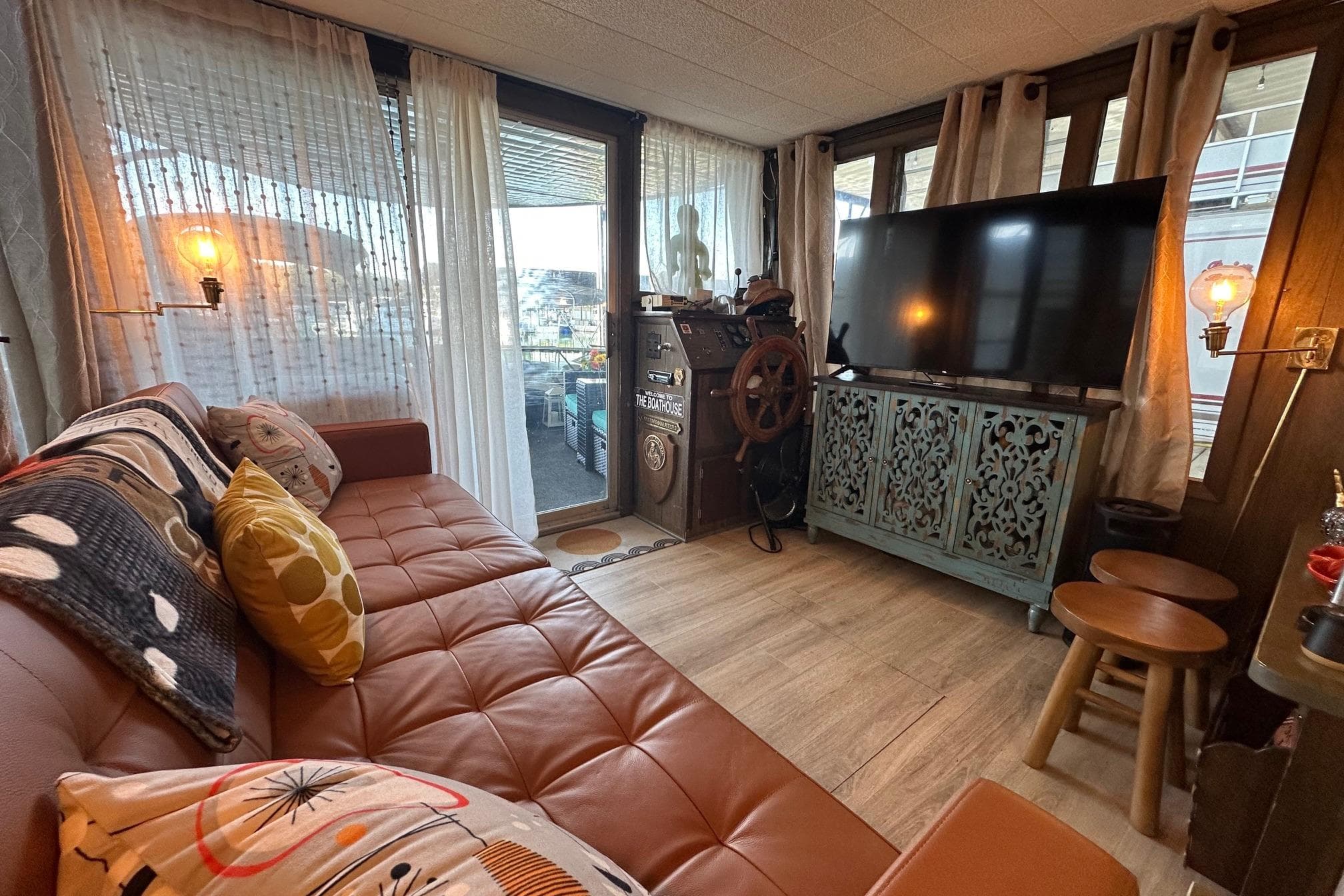 Cozy 1966 Lazy Days houseboat interior with vintage decor, large TV, and comfortable seating.