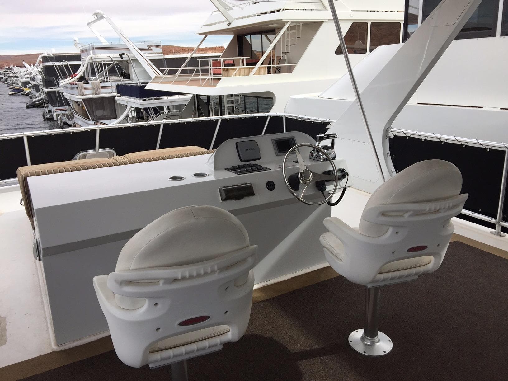 Helm of 2012 Bravada Ho'okipa Trip 13 houseboat with dual white captain chairs.