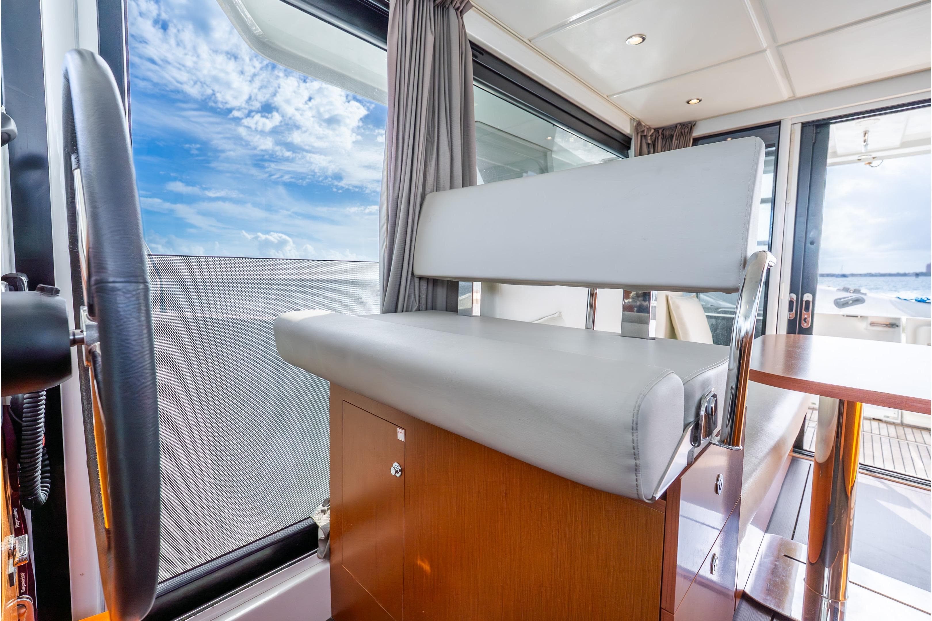 Interior of 2017 Beneteau Swift Trawler 30 with helm seat and ocean view.