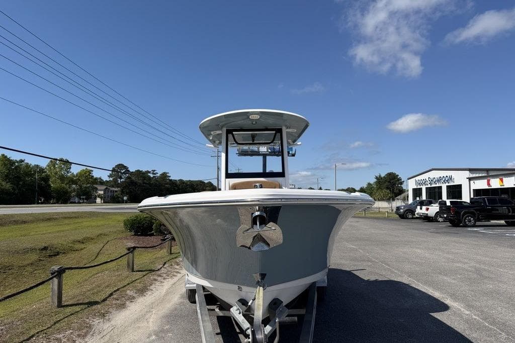 2024 Sea Hunt Ultra 265 SE boat on trailer, parked near dealership under clear sky.