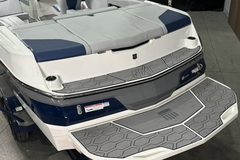 2023 MasterCraft NXT24 boat rear view with cushioned seating and non-slip deck.