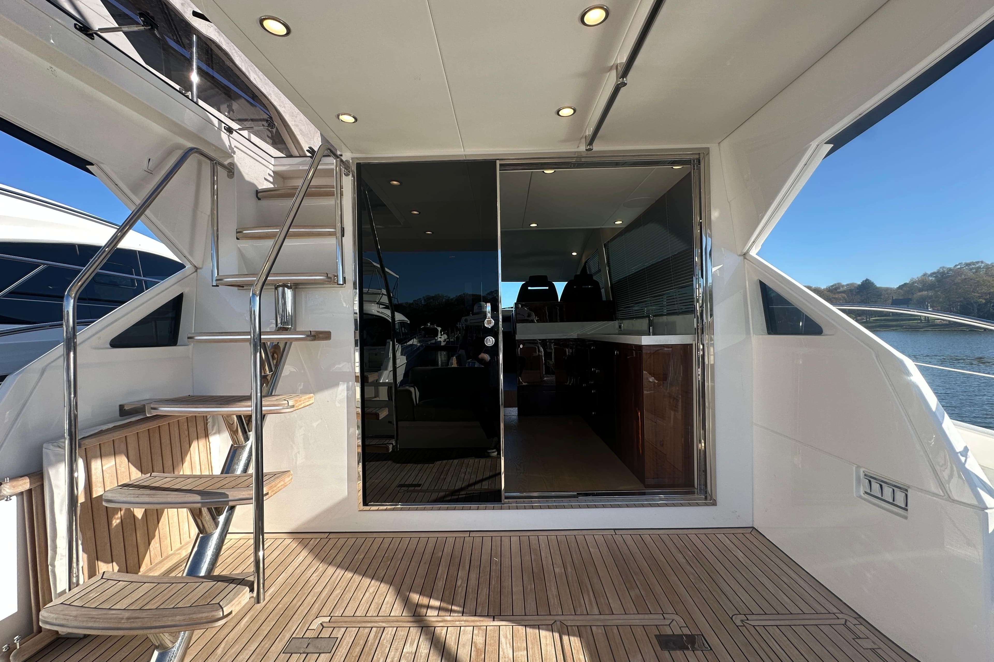 2024 Fairline Squadron 50 yacht interior with spiral staircase and sliding glass doors.