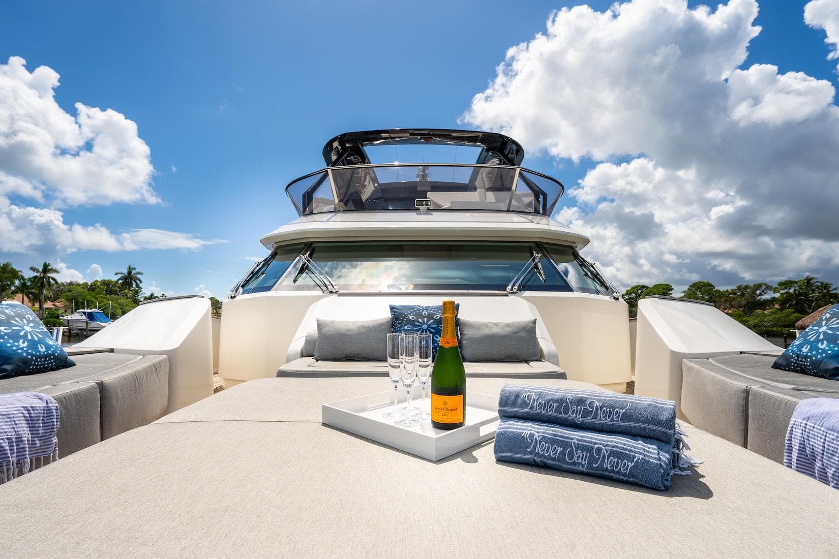 Luxurious 2015 Monte Carlo Yachts MCY 86 with champagne on deck under blue skies.