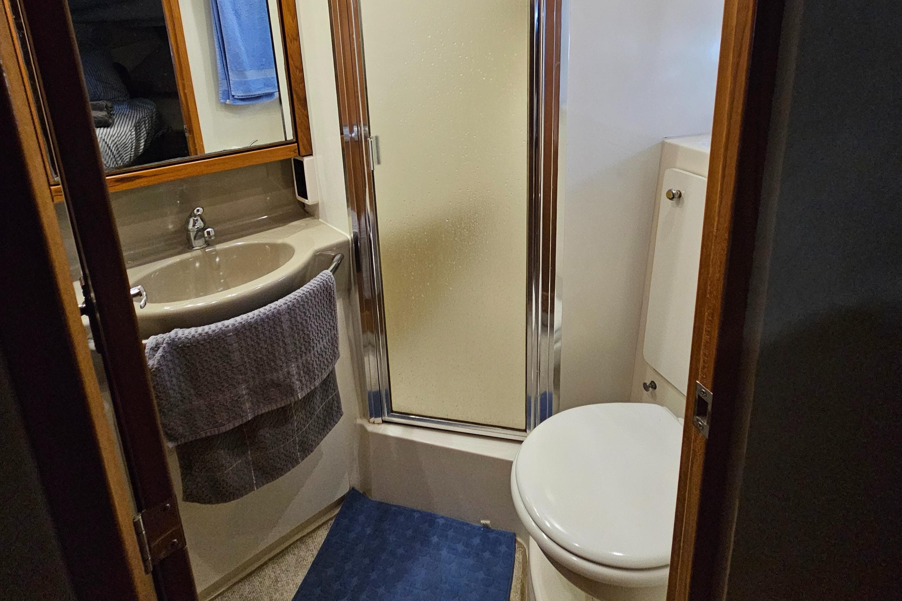 Bathroom interior of 1997 Bayliner 3788 Command Bridge Motoryacht with shower, sink, and toilet.