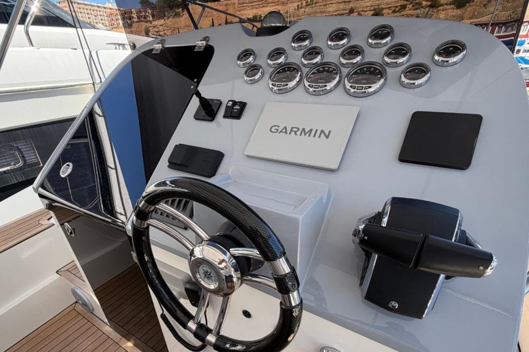 Helm of Scanner Envy 950 boat with Garmin navigation system, steering wheel, and gauges.