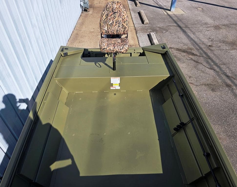2025 Lowe Roughneck RX1660 Tiller Steer boat with camouflage seat, parked outdoors.