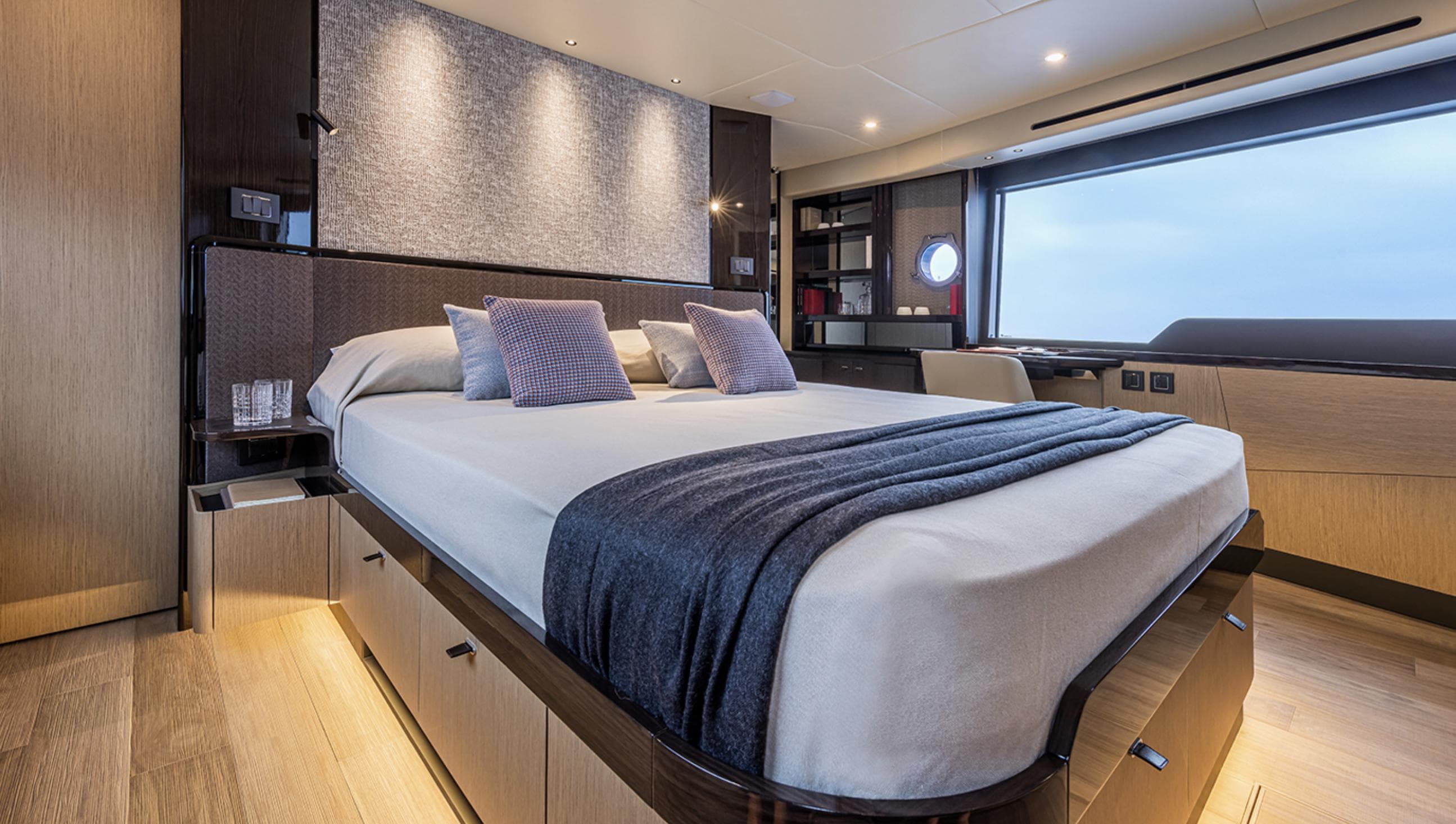 Luxurious bedroom interior of 2025 Absolute 56 FLY yacht with modern design and large window.