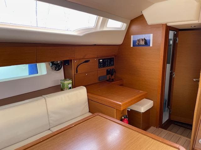 Interior of 2019 Jeanneau 54 yacht with wooden finish and seating area.