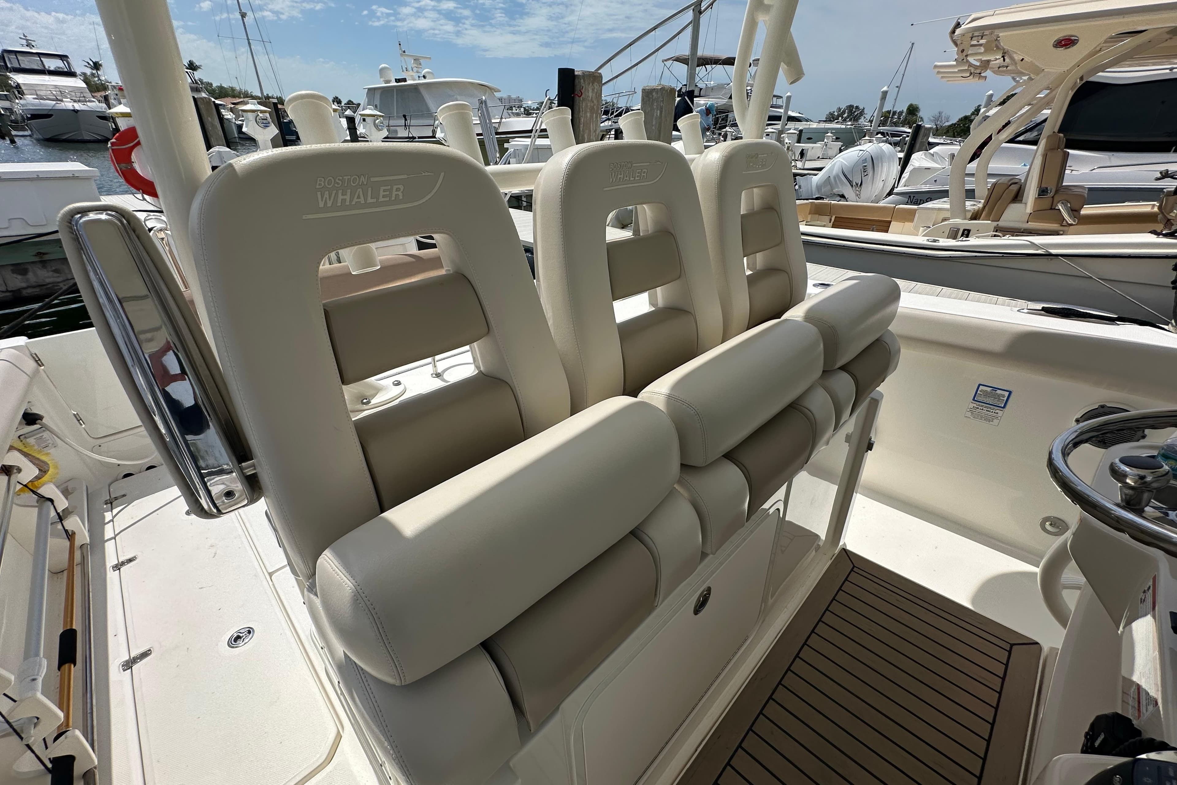 2018 Boston Whaler 350 Outrage boat interior with cushioned seating and steering wheel.