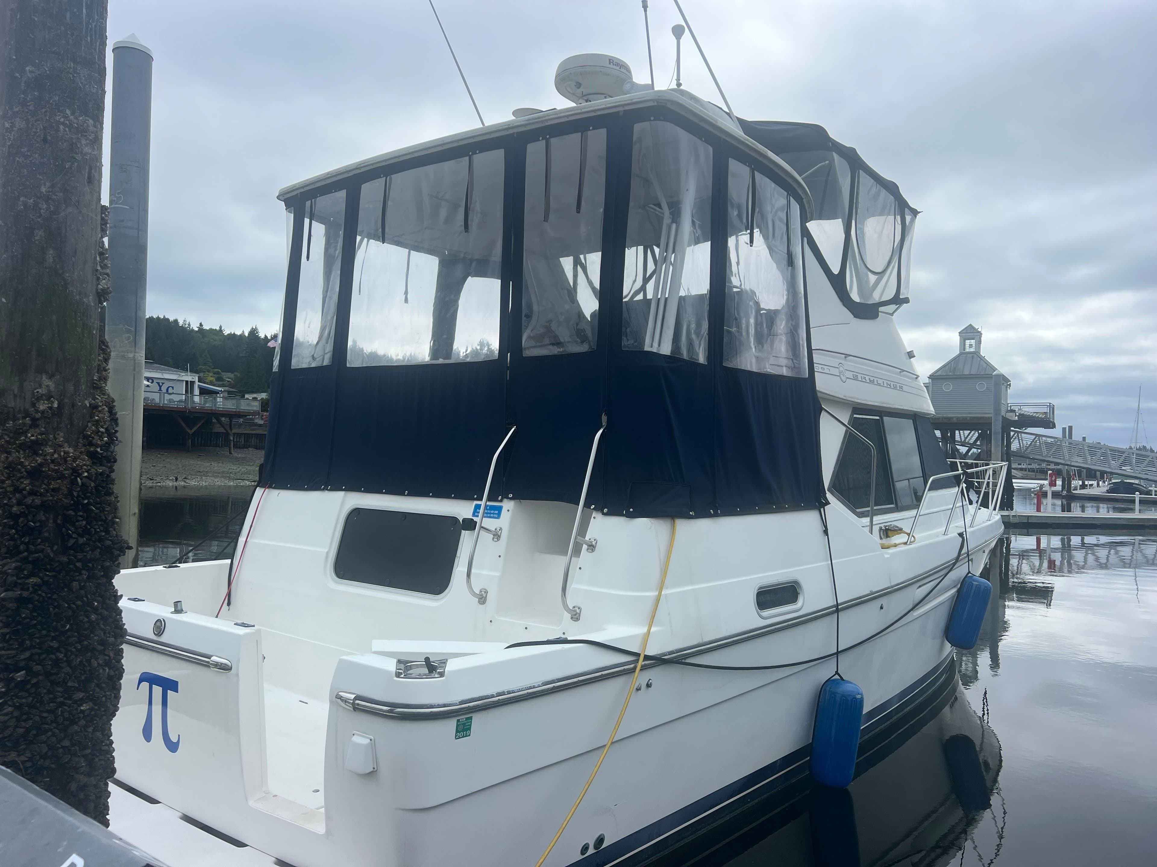 1999 Bayliner 4087 Aft Cabin Motoryacht docked at marina under cloudy sky.