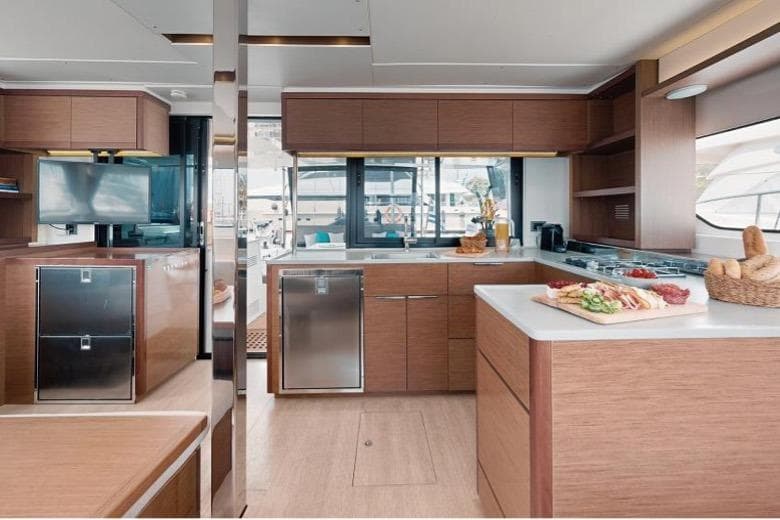 Luxurious 2020 Lagoon 46 yacht interior with modern kitchen and elegant wood finishes.