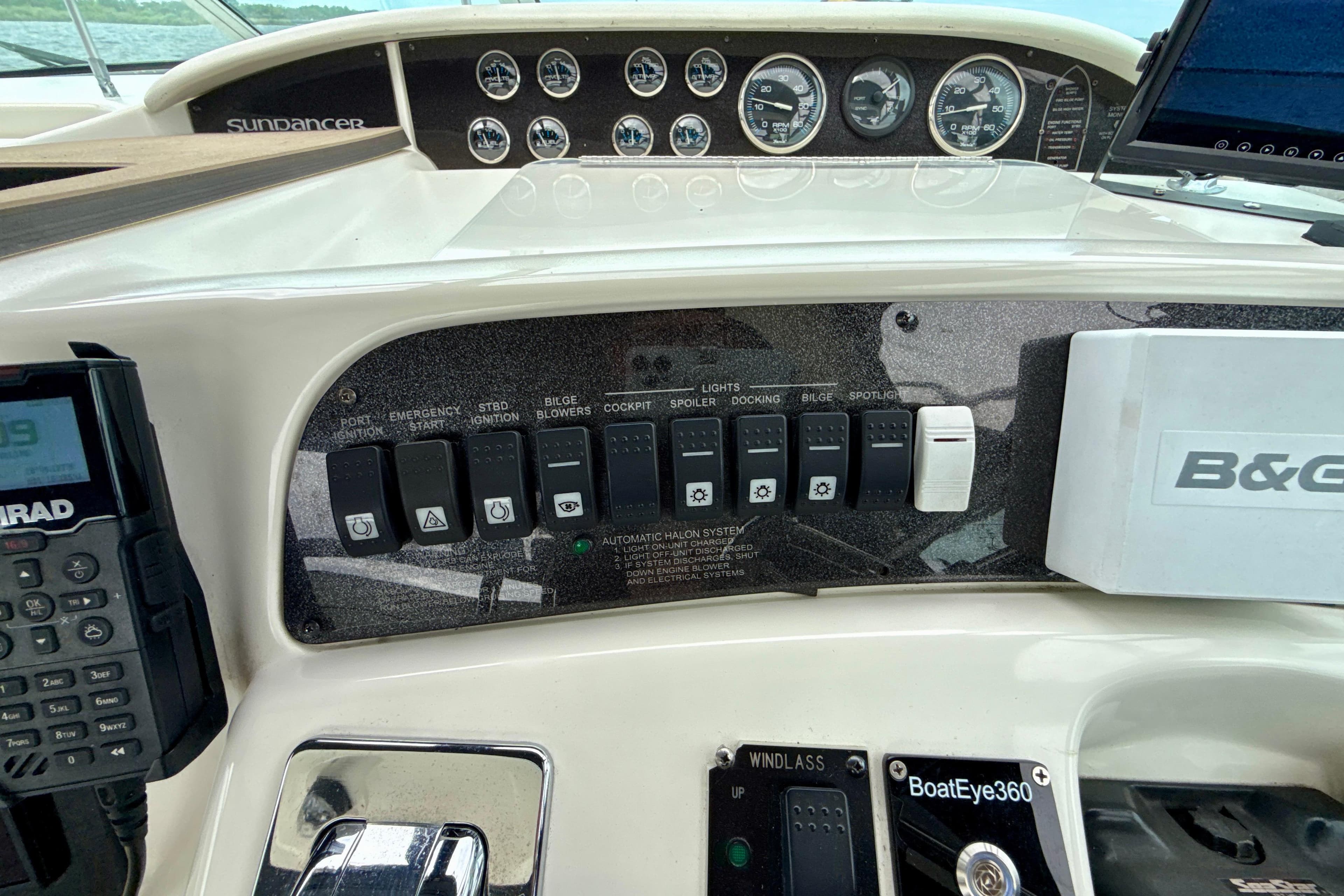 Control panel of a 1995 Sea Ray Sundancer 370 boat with switches and gauges.