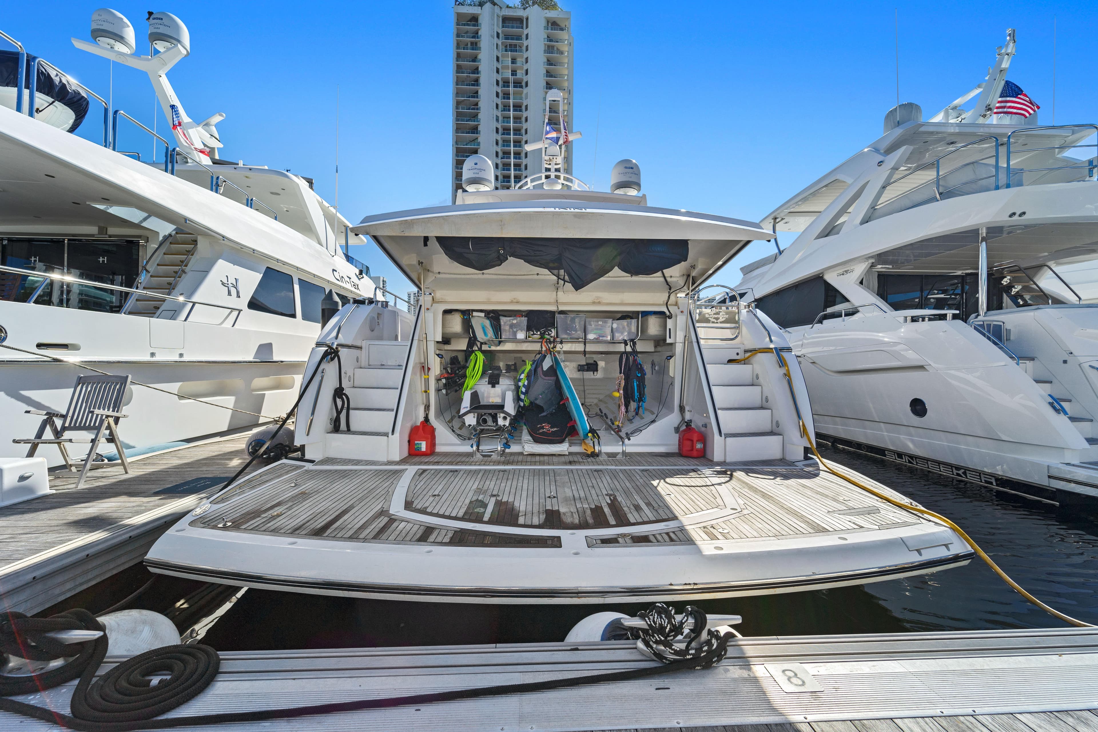 2013 Sunseeker Predator 84 yacht docked, showcasing open rear deck and water sports equipment.