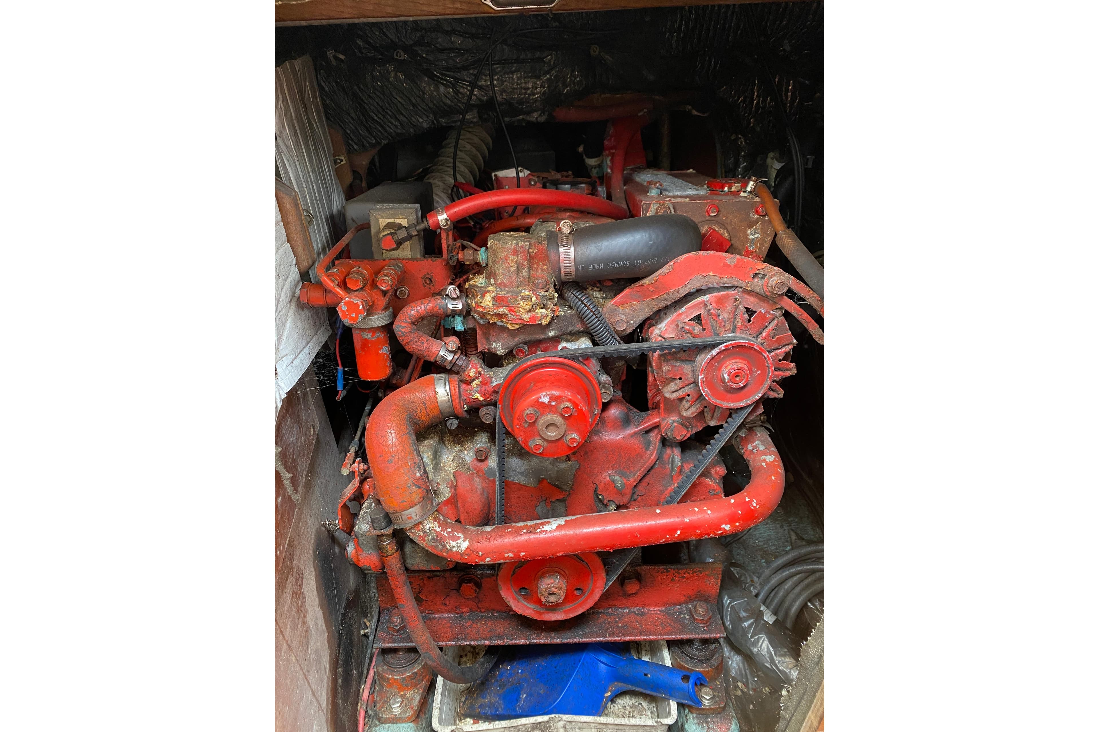 Red engine of a 1986 Sabre 36 boat, showing belts and hoses.
