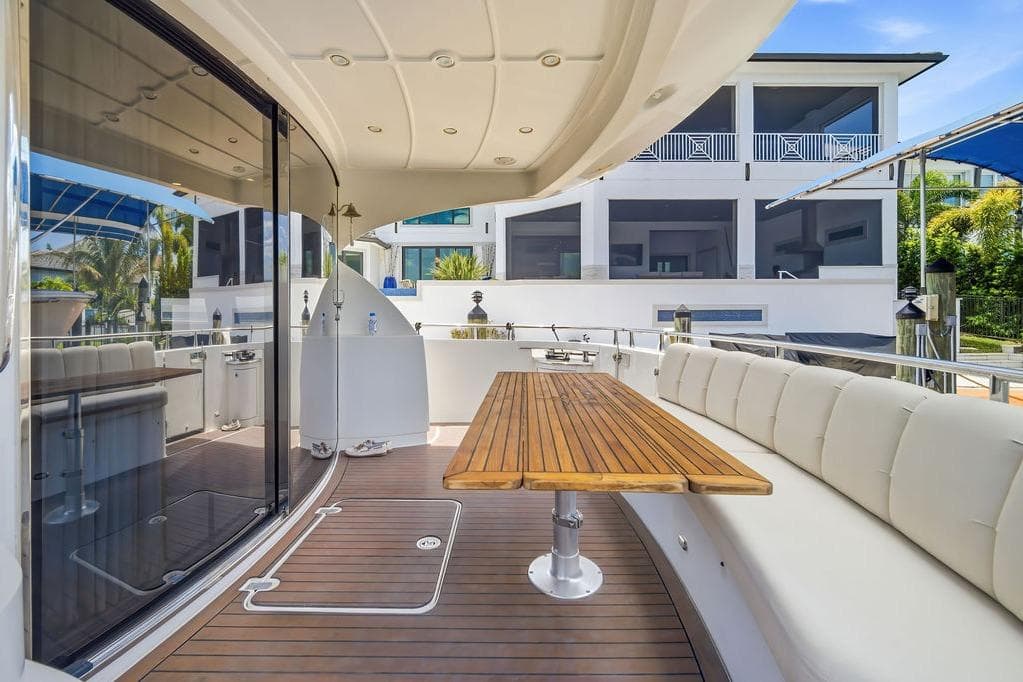Luxurious 2006 Marquis 59 yacht deck with elegant seating and wooden table.