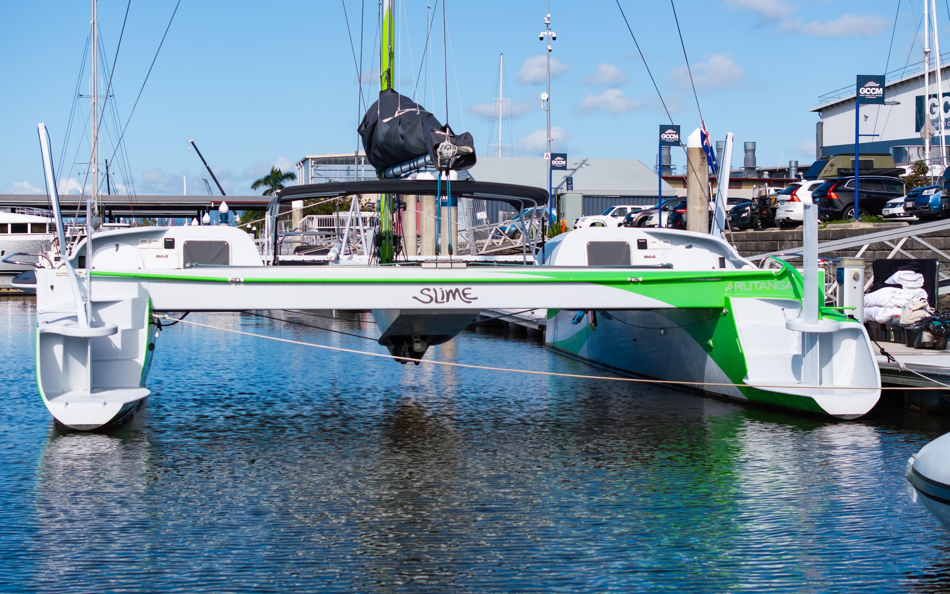 Custom 2016 John Hughes Bladerunner trimaran docked in marina, featuring green and white design.