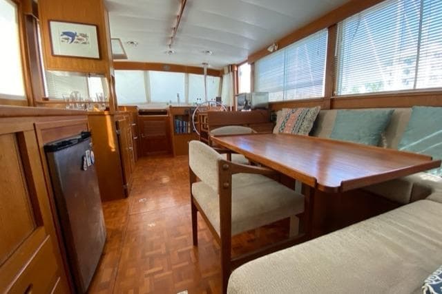 Interior of a 1977 Grand Banks 42 yacht with wooden furnishings and seating area.