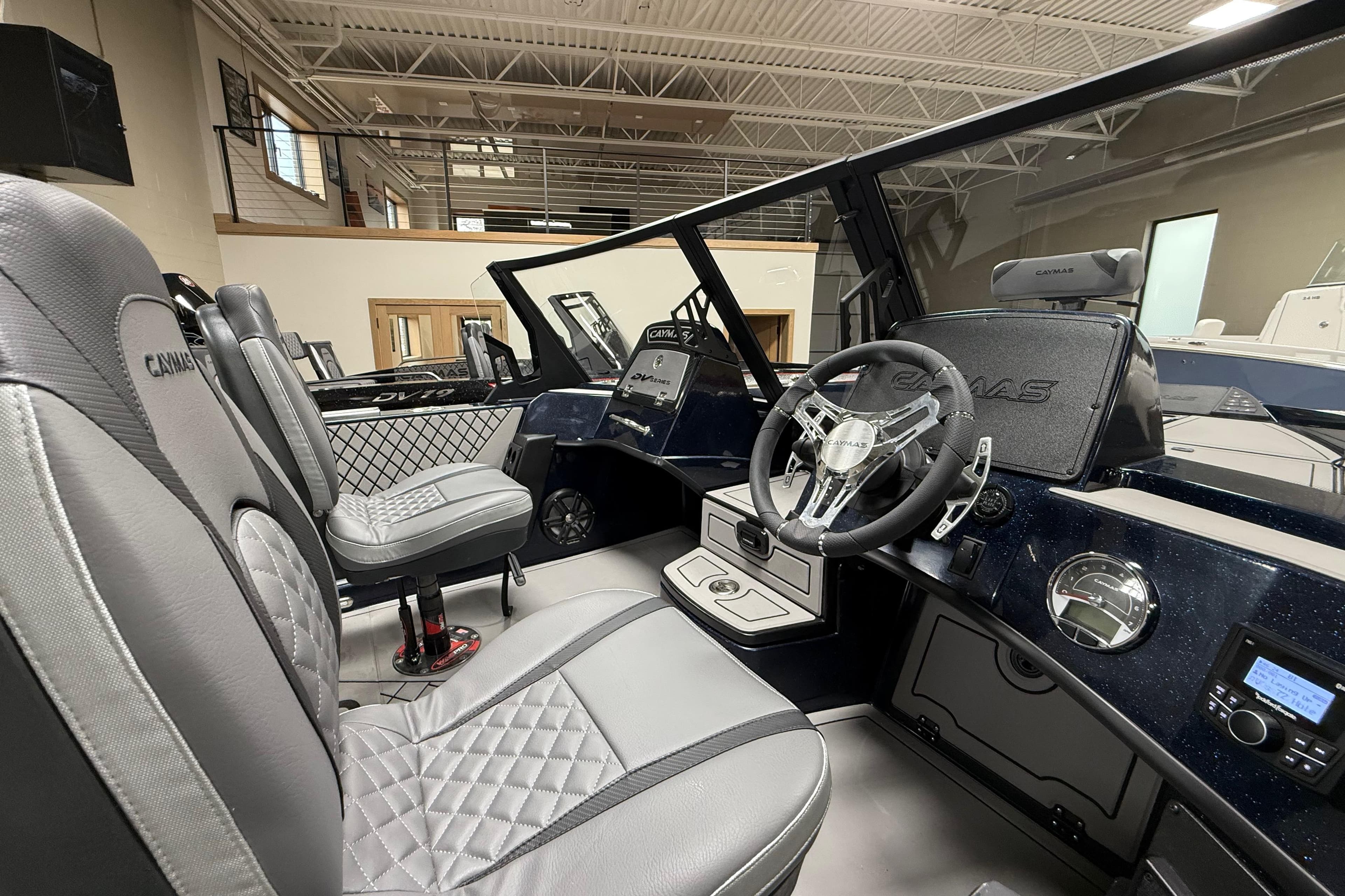 Interior of 2026 Caymas DV 22 boat with modern steering and luxurious seating.