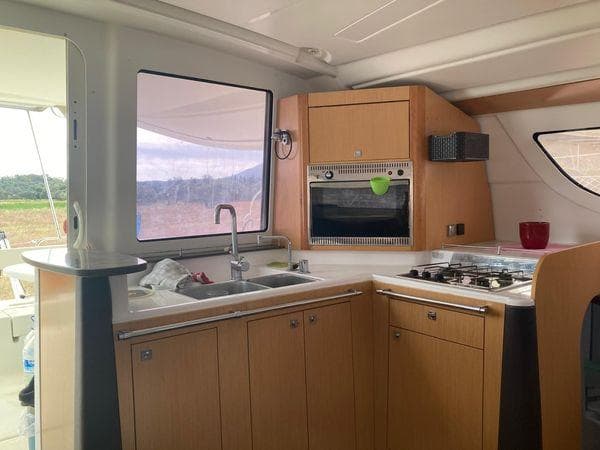Modern kitchen interior of 2011 Fountaine Pajot Lipari 41 catamaran with wood cabinetry and appliances.