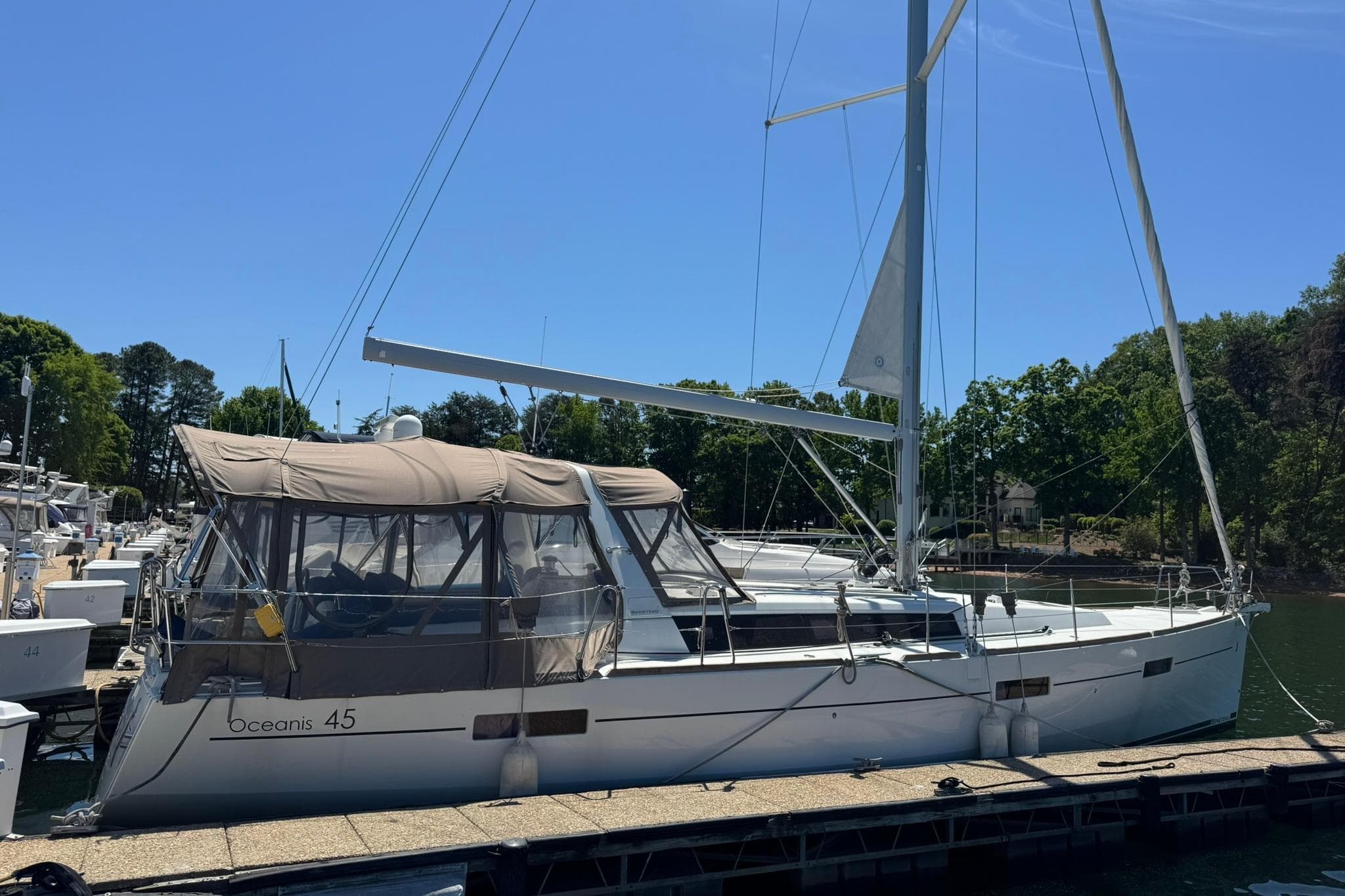 2014 Beneteau Oceanis 45 sailboat docked at a marina under clear blue skies.