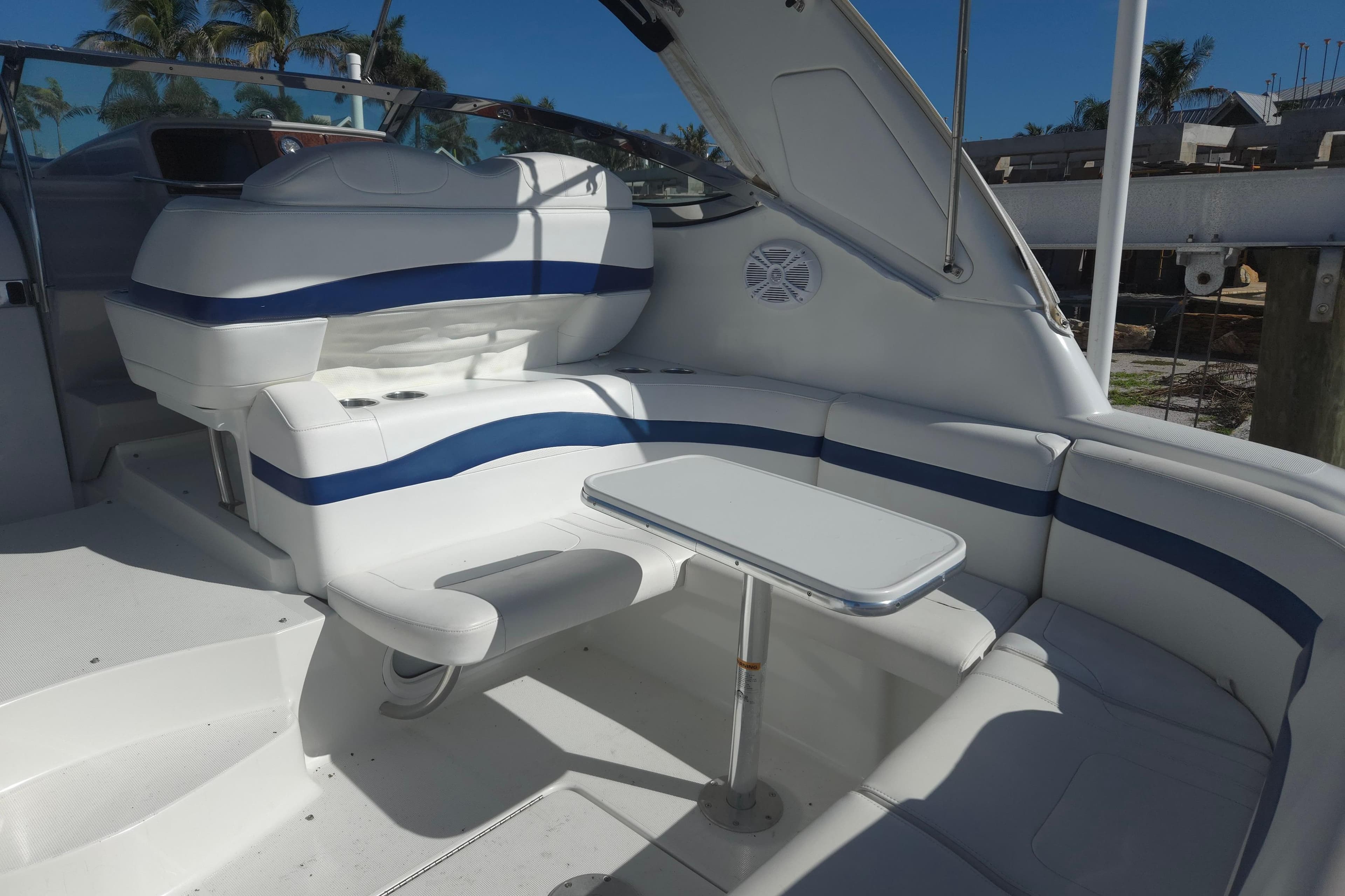 2005 Formula 37 Performance Cruiser interior with white seating and table, docked under blue sky.