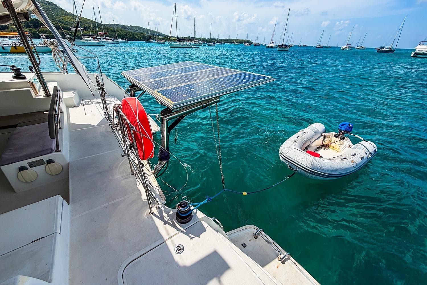 Lagoon 400 catamaran with solar panels and dinghy in a scenic marina, 2010 model.