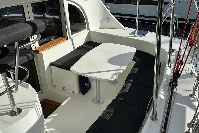2018 Lagoon 380 catamaran cockpit with seating and table, featuring sleek design and modern amenities.