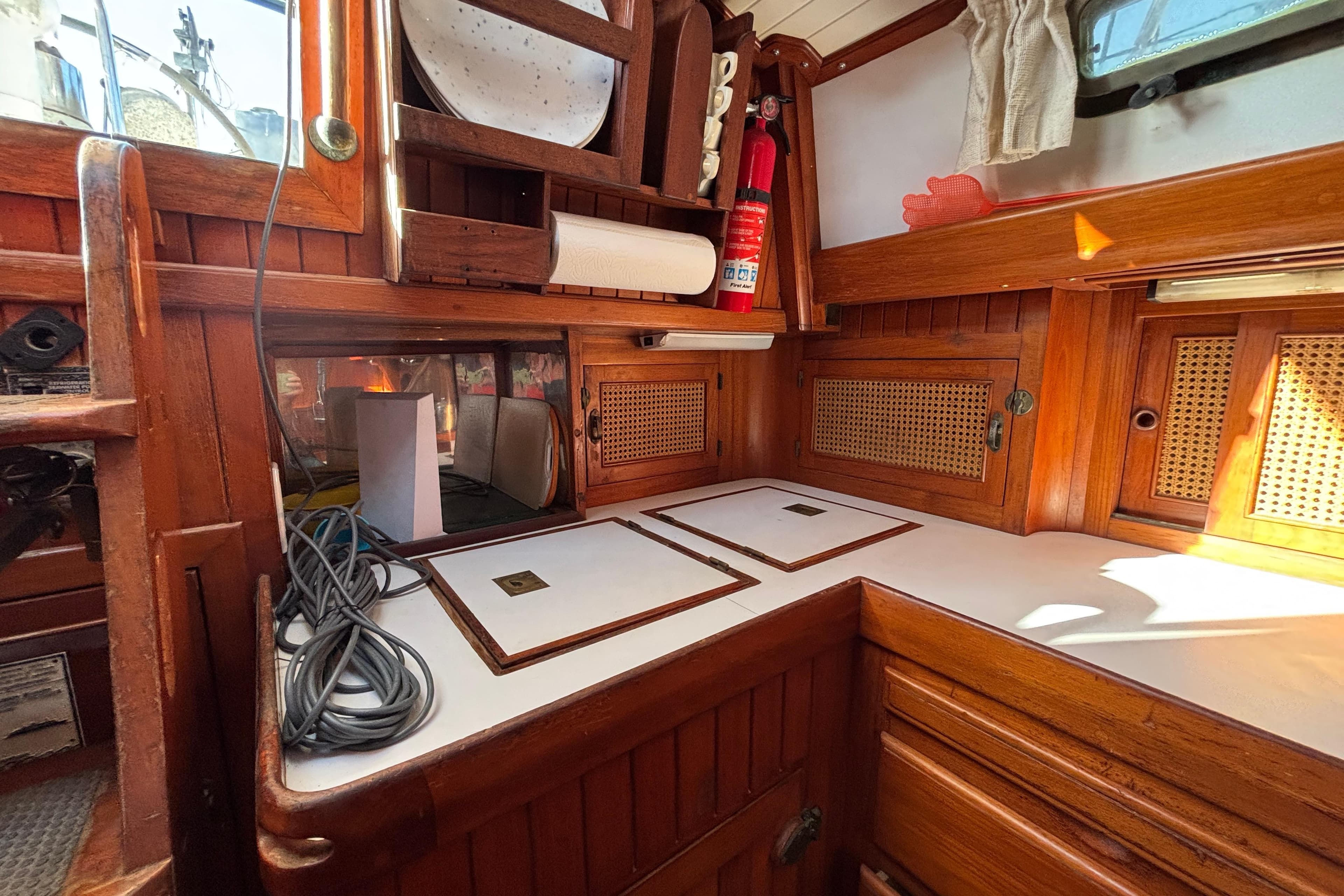 1987 Passport 40 yacht interior with wooden cabinetry and kitchen area.