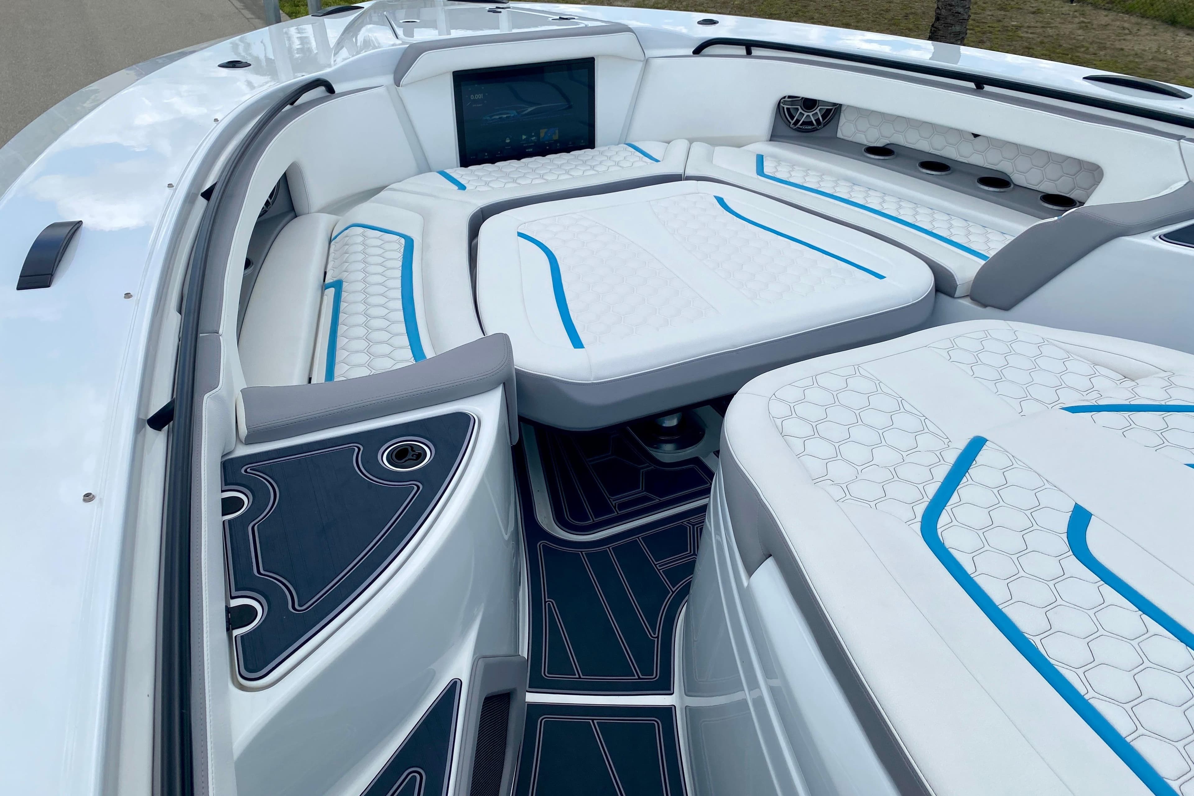 Luxurious interior of 2024 MTI V50 boat with white and blue seating.