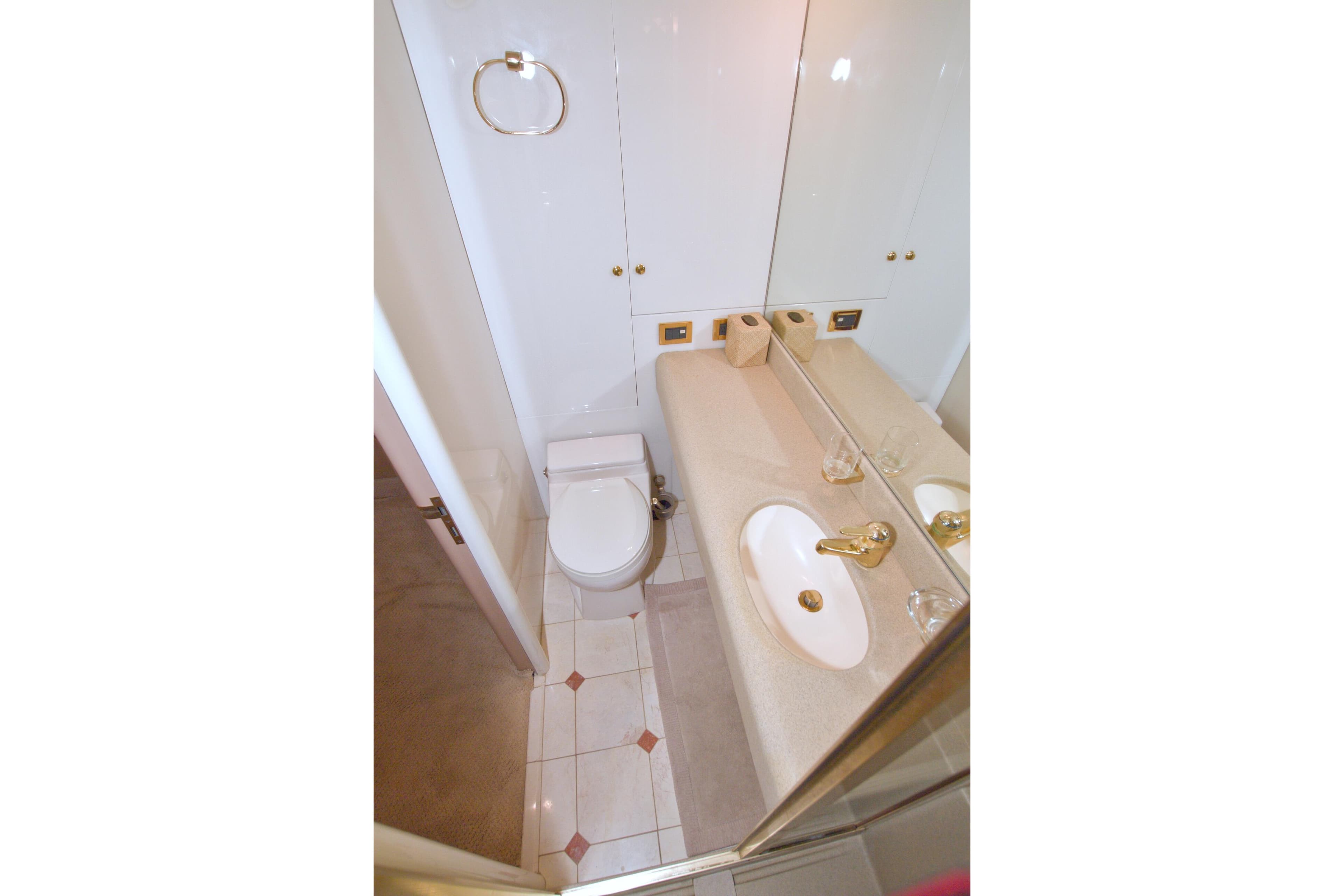 Bathroom interior of 1998 Lazzara 76 Skylounge Grand Salon yacht, featuring elegant fixtures.