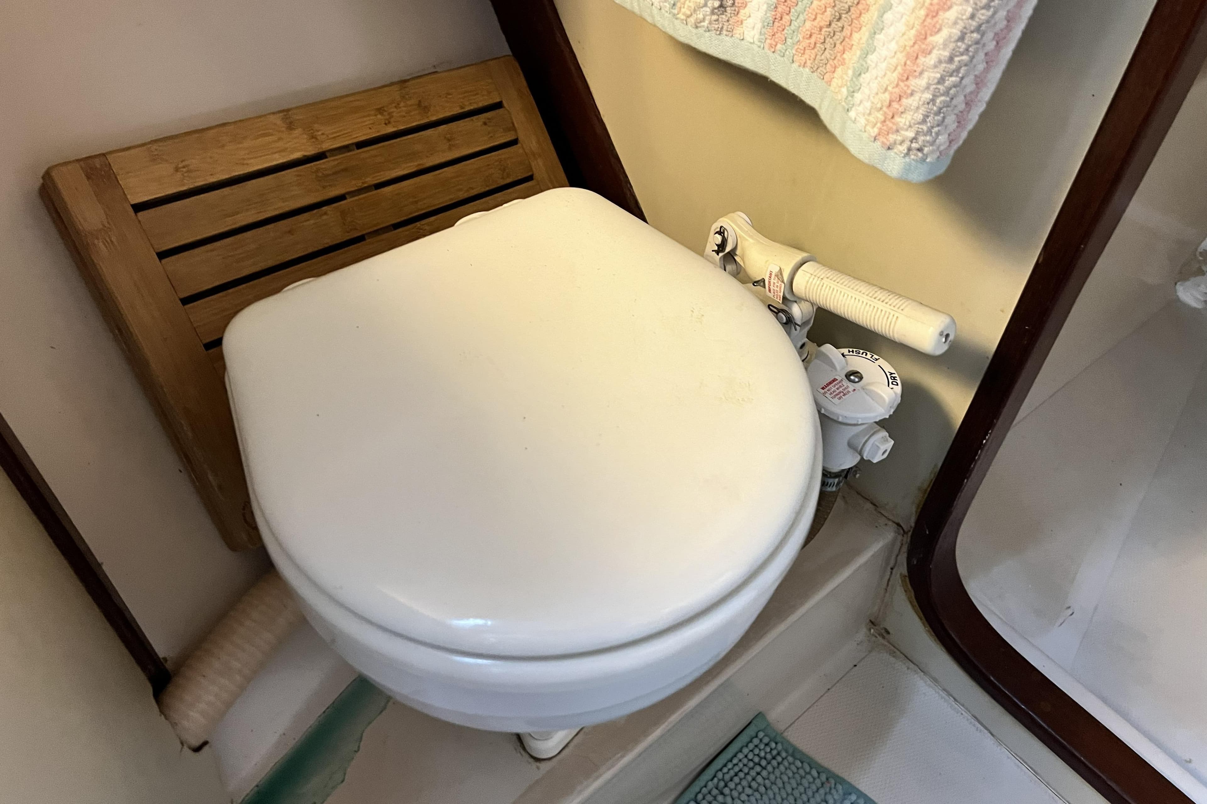 1985 Gulfstar Hirsch Center Cockpit bathroom with marine toilet and wooden seat.