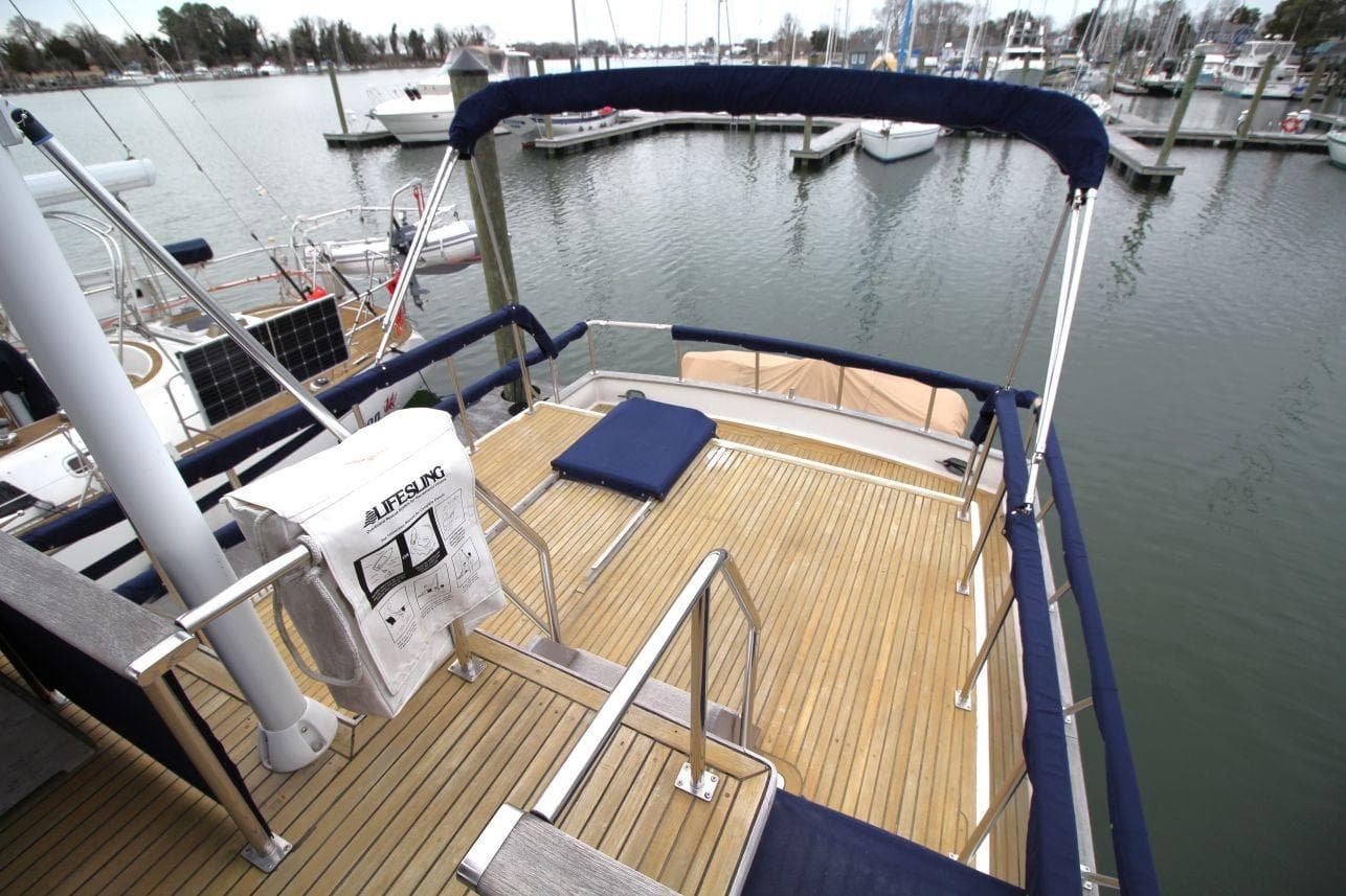 1986 DeFever 41 Trawler deck with railing, docked at marina.