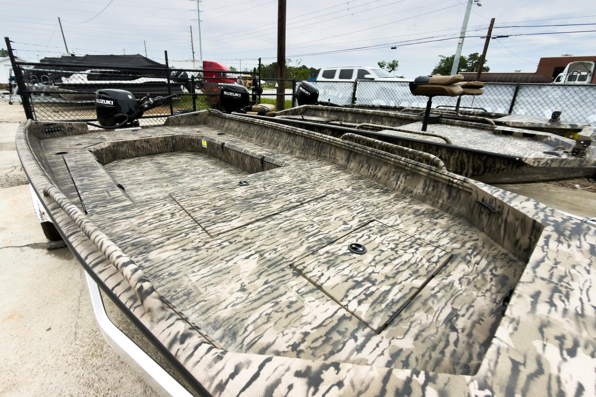 2026 Excel 183 Tomahawk boat with camouflage design, parked outdoors.