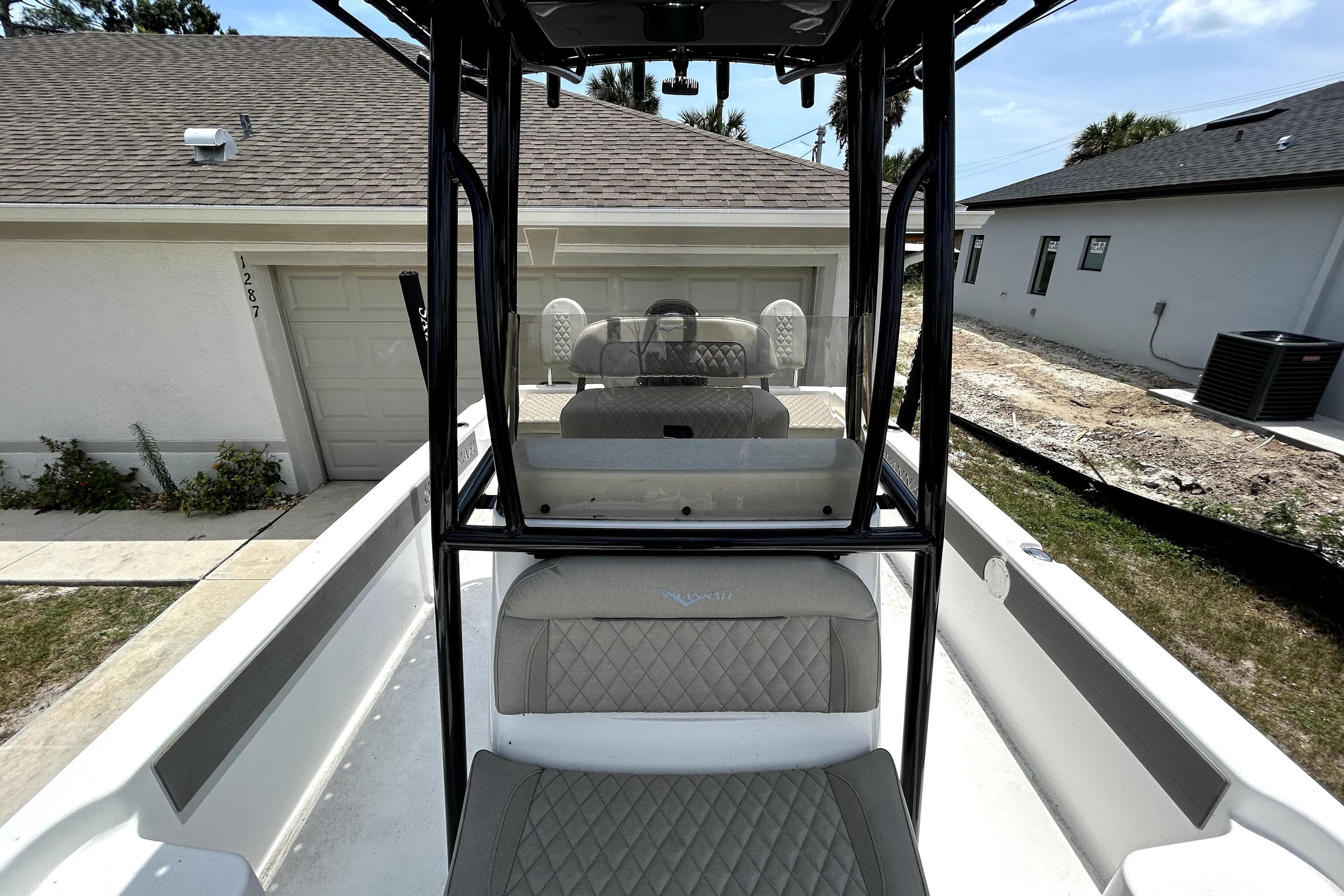 2025 Savannah 210X boat interior with quilted seats, parked near residential garage.