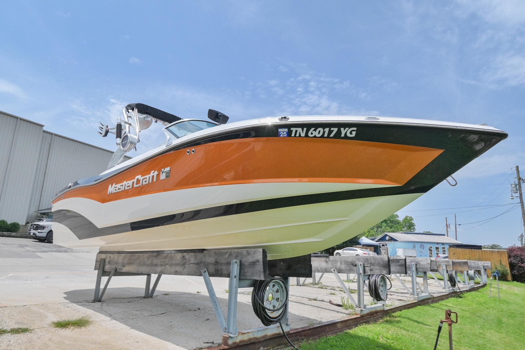 2018 MasterCraft XT23 boat on display, orange and white design, parked outdoors.