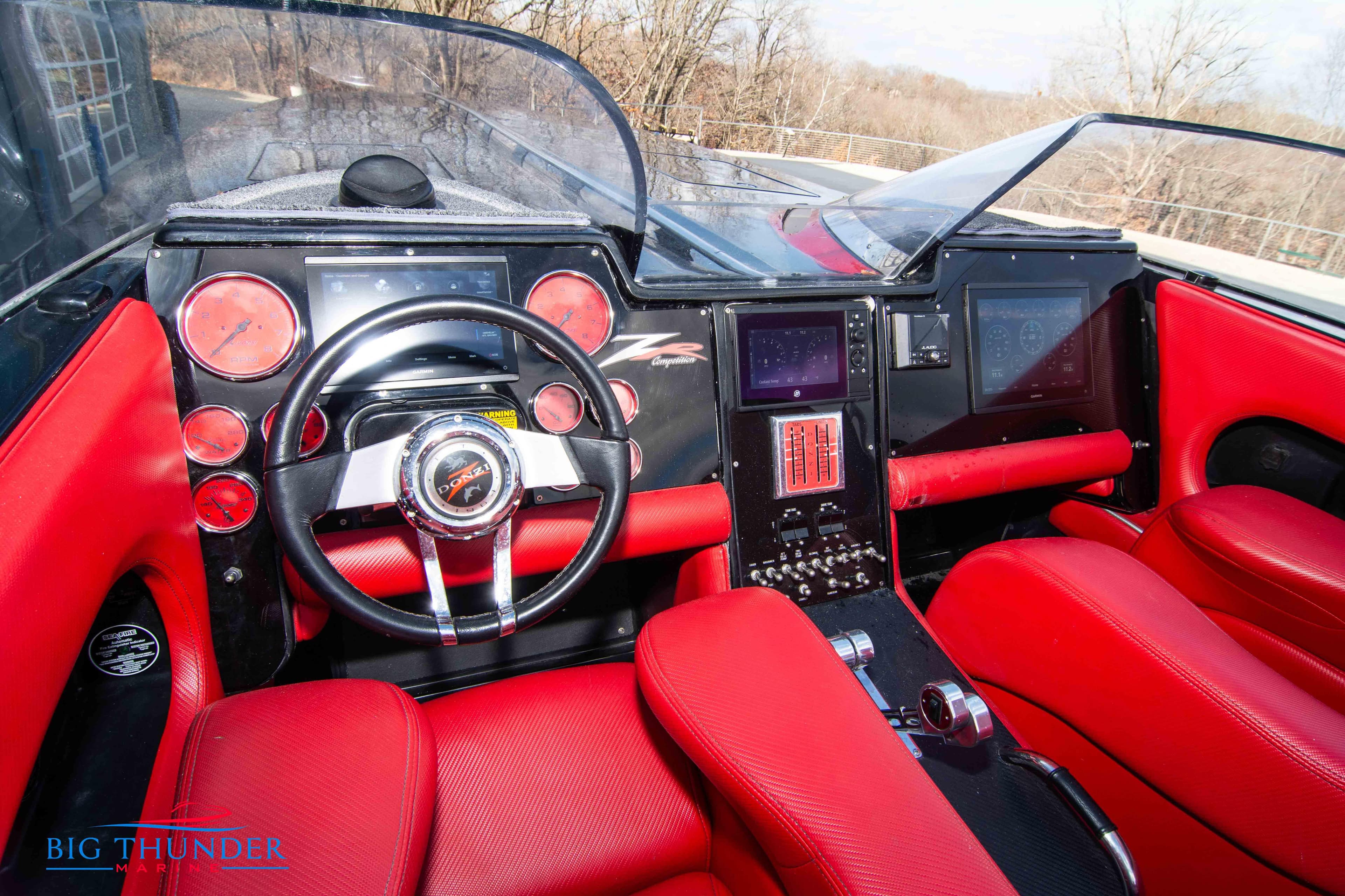 2009 Donzi 38 ZRC boat cockpit with red leather seats and modern dashboard.