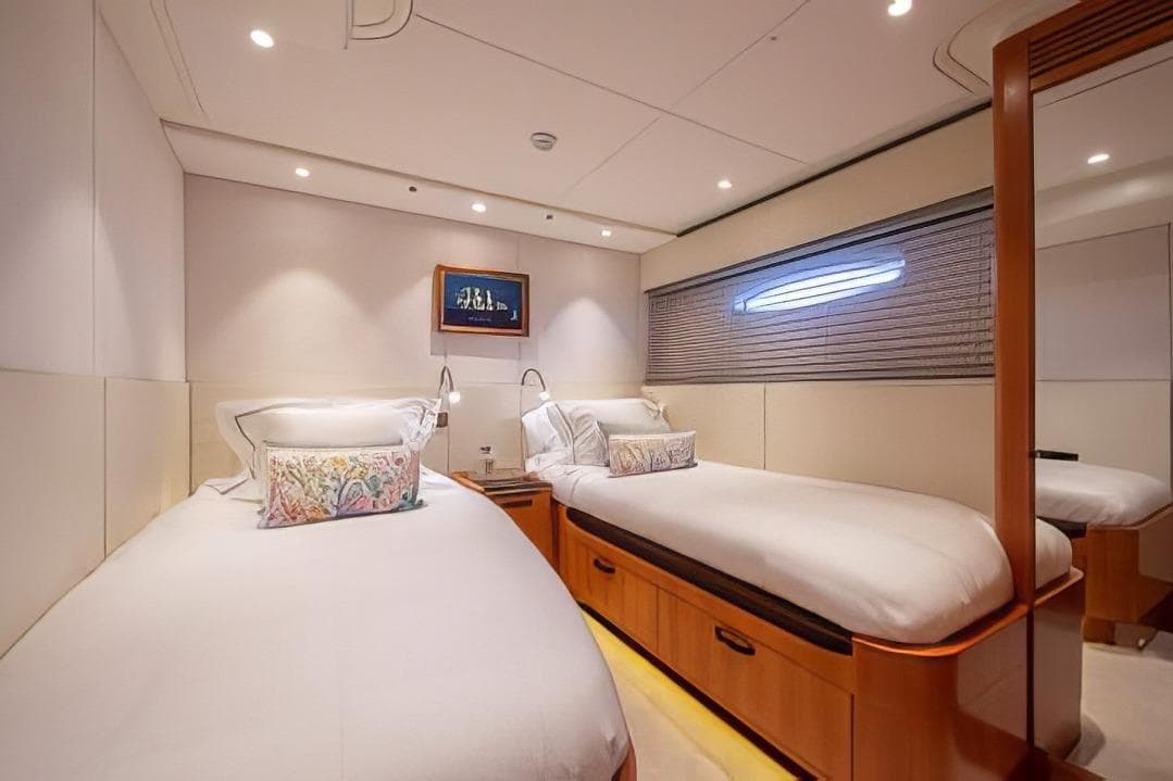 Luxurious twin cabin interior of 2018 Baltic 85 yacht, featuring elegant bedding and modern lighting.