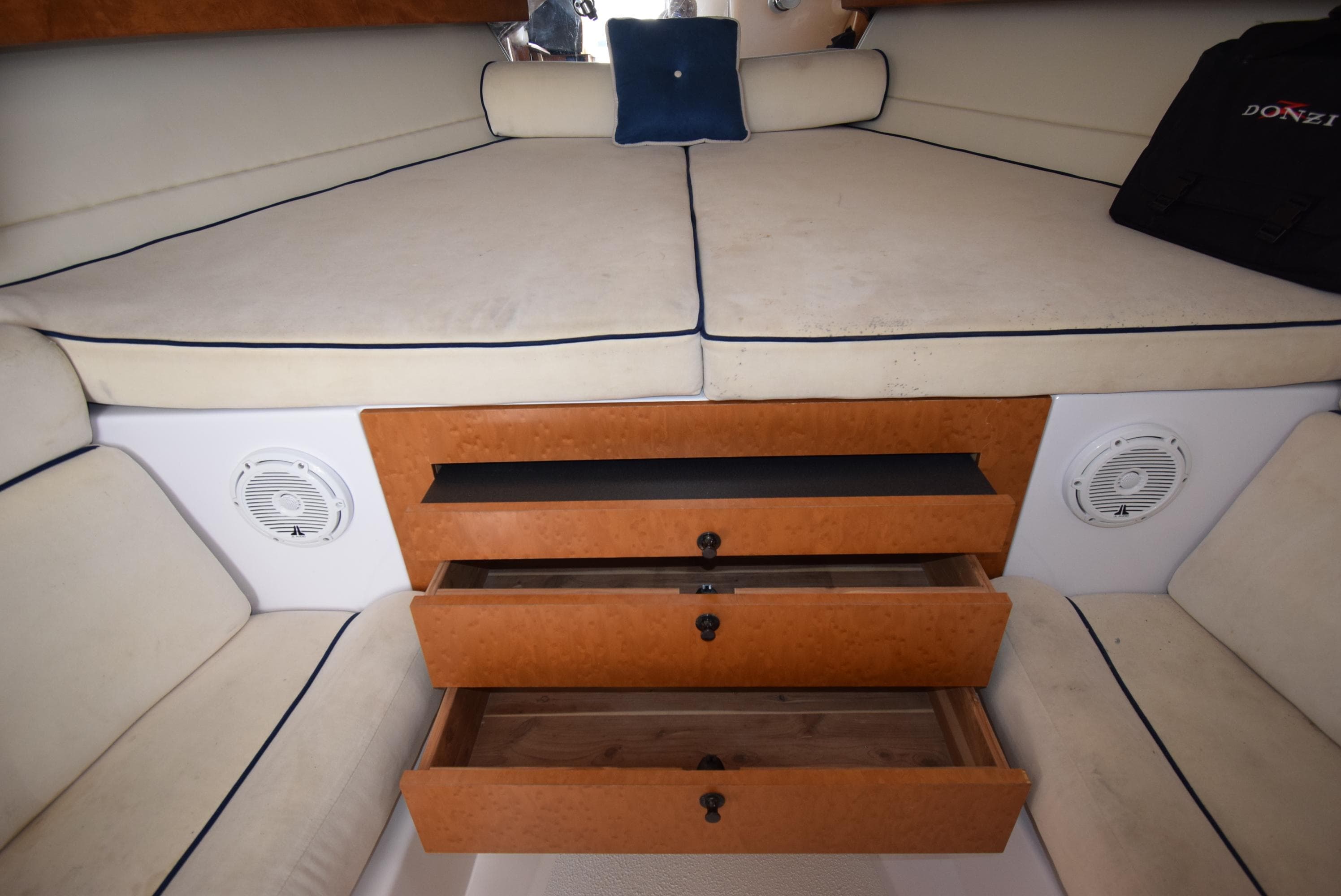 Interior cabin of 2005 Donzi 38 ZSF boat with storage drawers and cushioned seating.