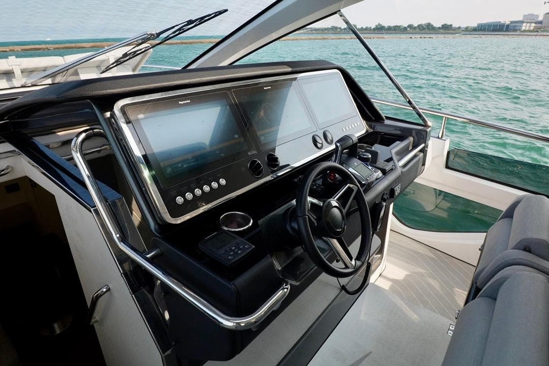 Helm of 2024 Azimut Verve 48 yacht with dual screens and steering wheel.
