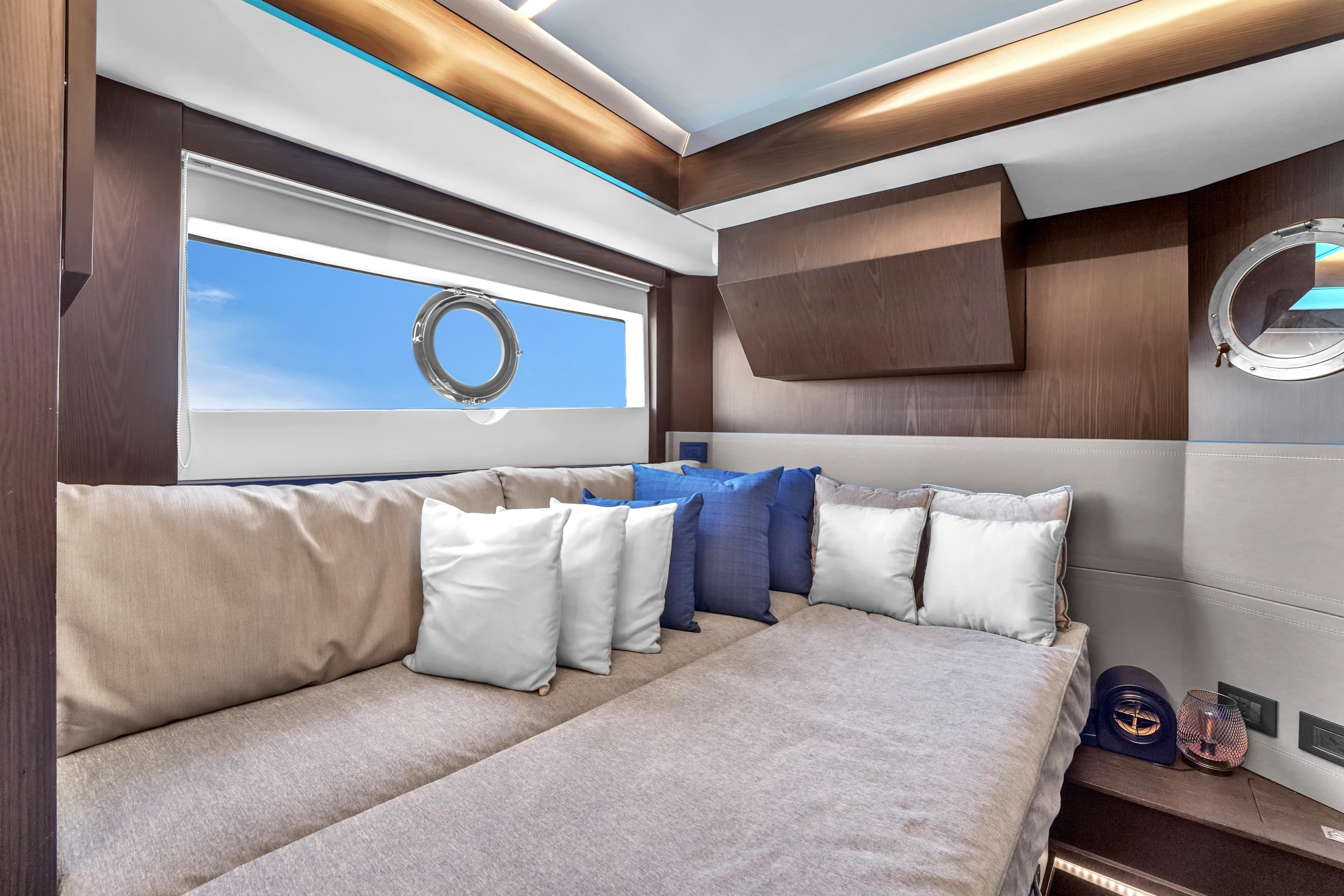 Luxurious interior of 2021 OKEAN 80 yacht with plush seating and porthole views.