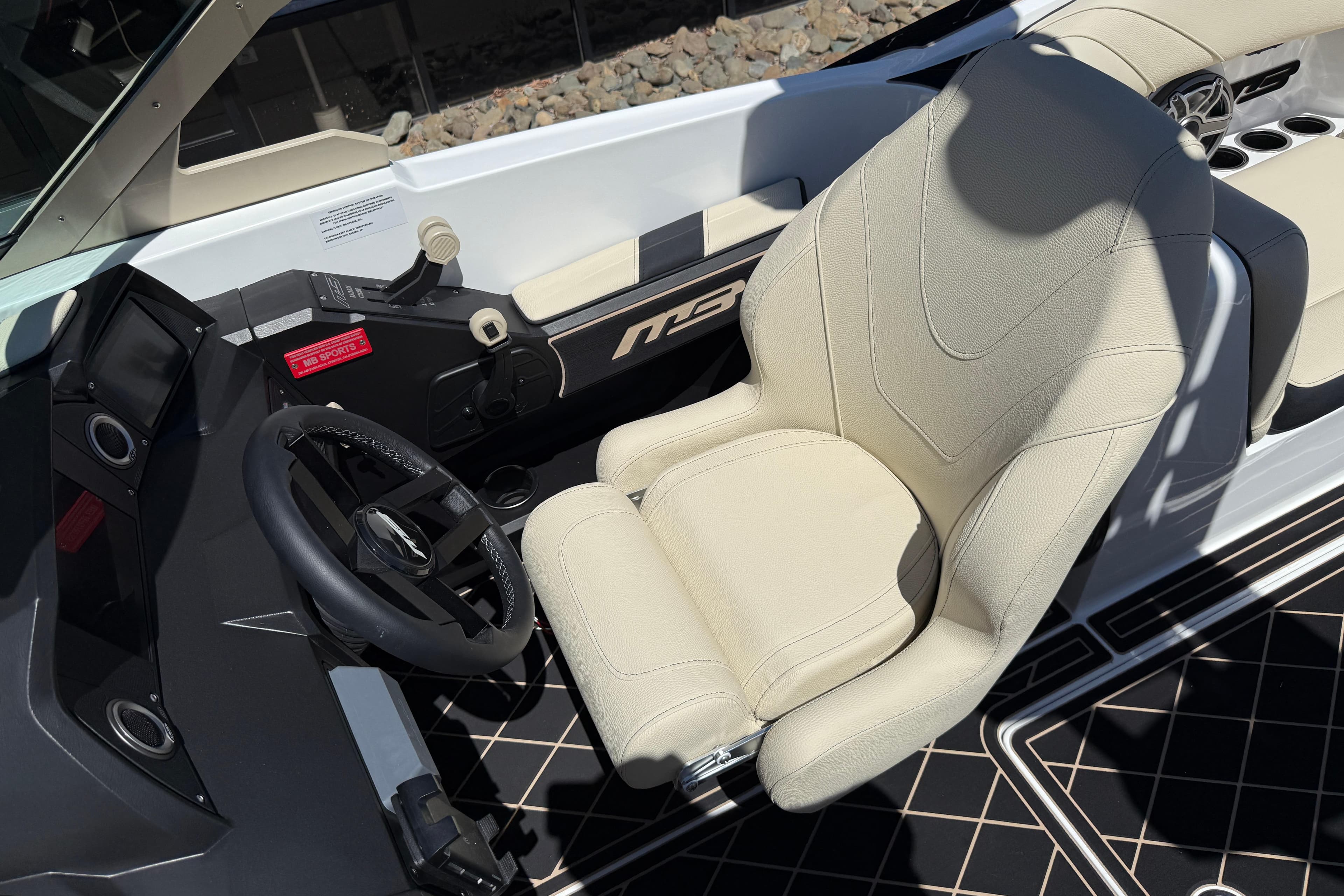 Captain's seat and steering wheel of 2026 MB B52 23 Alpha boat interior.