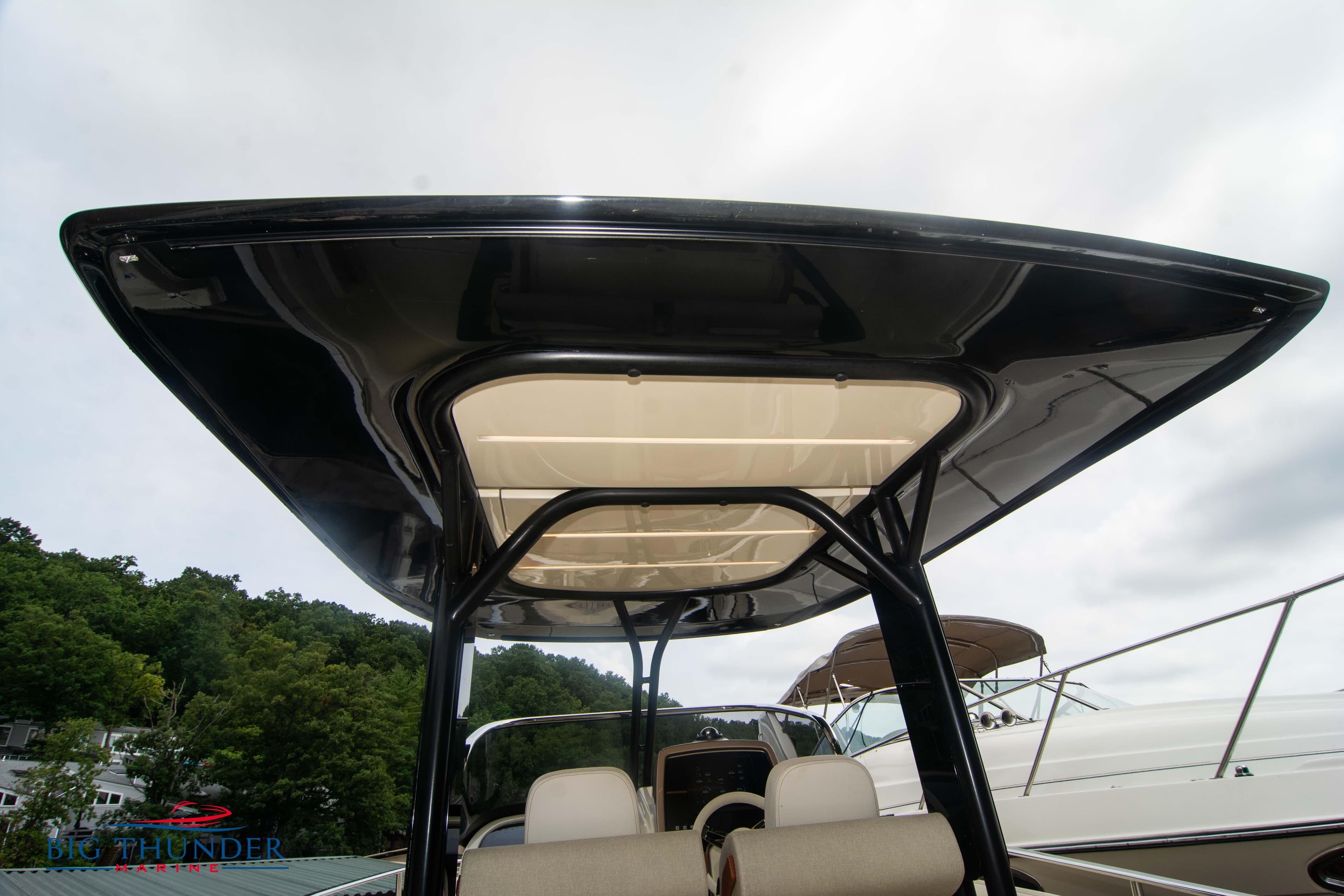 2024 Invictus TT280S boat with sleek black hardtop and beige seating.